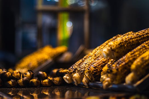 Delicious grilled corn cobs displayed on an outdoor stand, perfect for a summer snack.