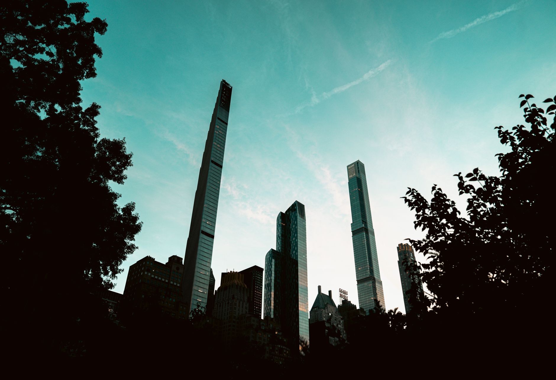 Silhouette of the New York City skyline at sunset with towering skyscrapers.