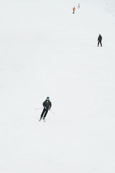 A group of skiers navigating down a snowy ski slope on a winter day, creating a serene scene.