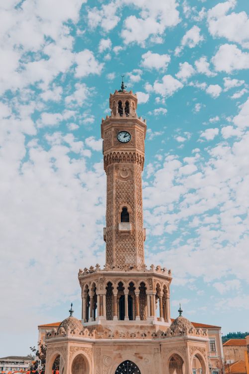 Free Historic Izmir Clock Tower set against a clear blue sky with clouds in Turkey. Stock Photo