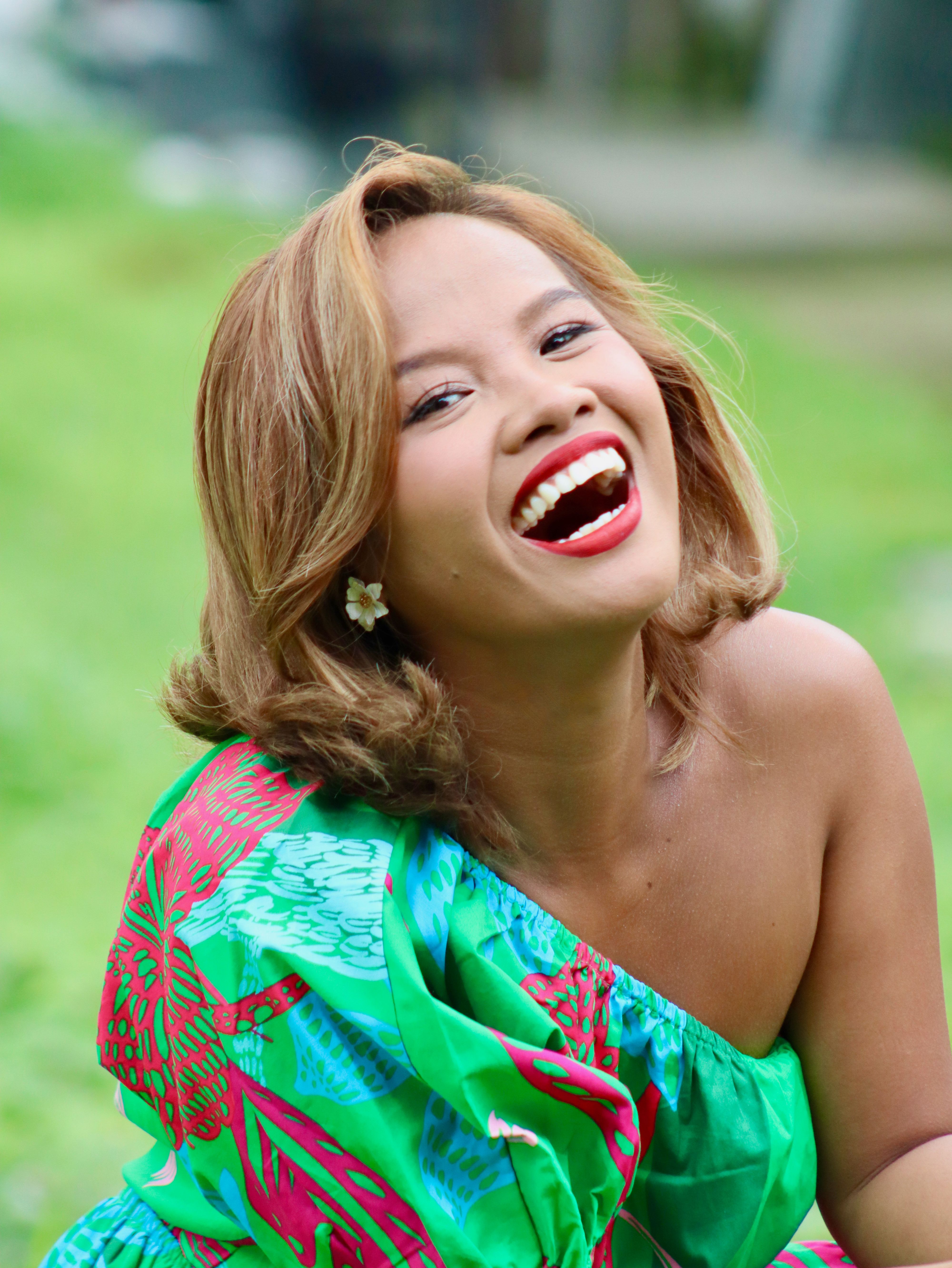 Joyful woman in colorful dress laughing outdoors in Lawaan, Eastern Visayas, Philippines.