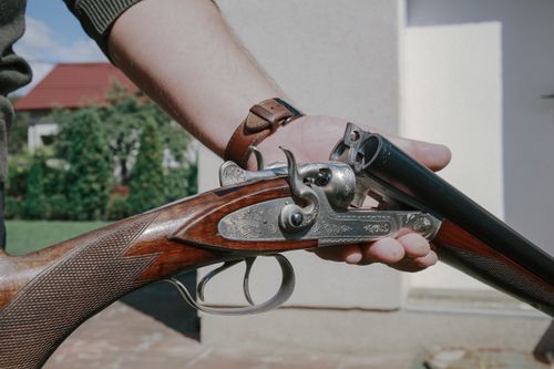 Free Close-up of a handcrafted double barrel shotgun showcasing intricate metal engravings and walnut wood. Stock Photo