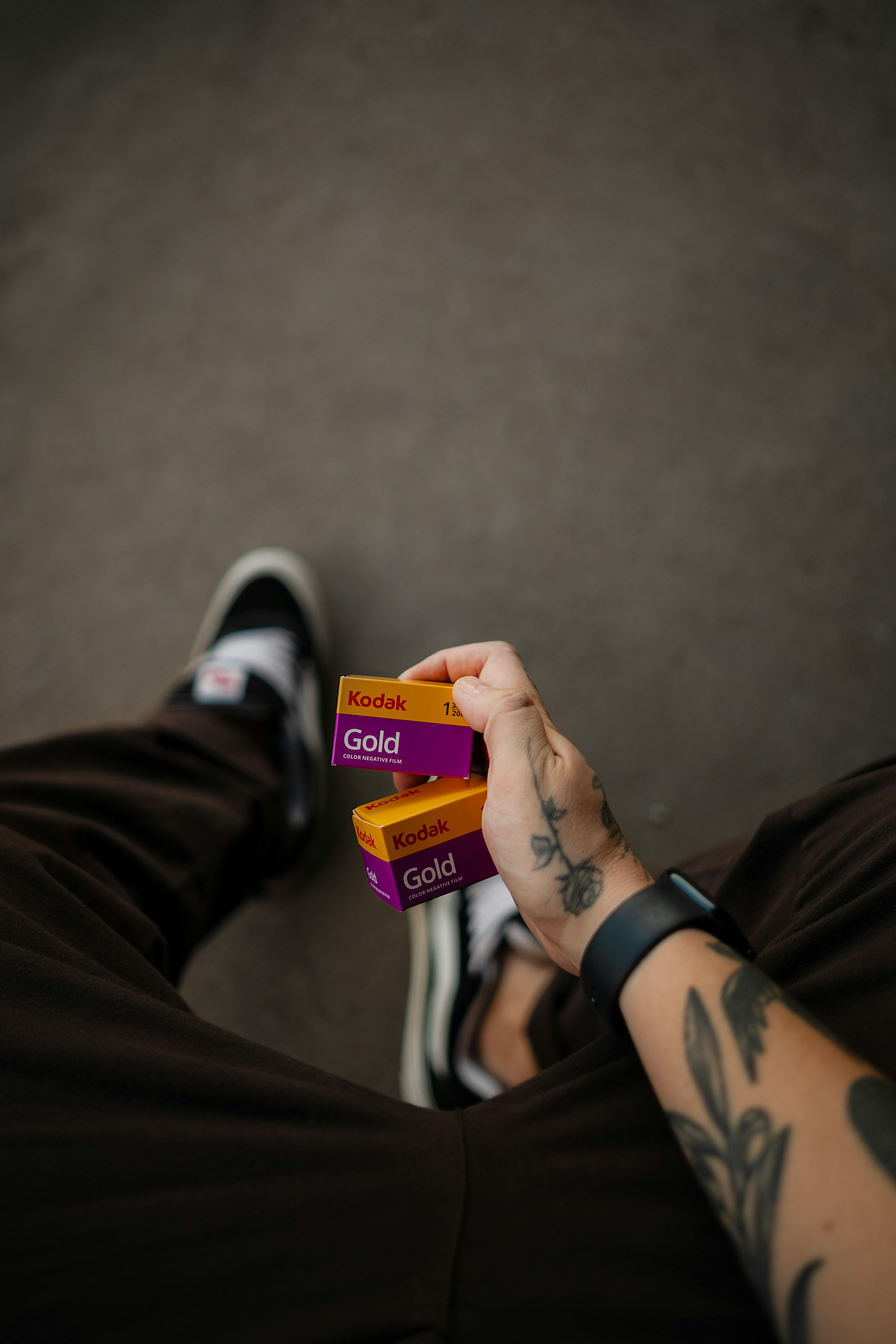 Free Tattooed hand holding Kodak Gold film in Mirassol, São Paulo. A nod to analog photography culture. Stock Photo