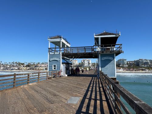 Free A clear day at Oceanside Pier with waves and the cityscape in the background. Stock Photo
