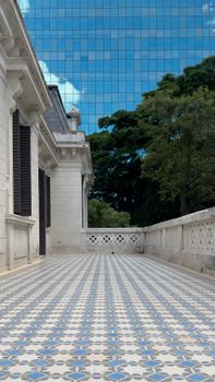 Spacious terrace with elegant blue mosaic tiles and classic architecture in SP, Brazil, against a cityscape and sky backdrop.