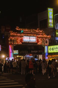 Explore Taipei's vibrant Raohe Street Night Market at night with colorful lights and lively crowds.
