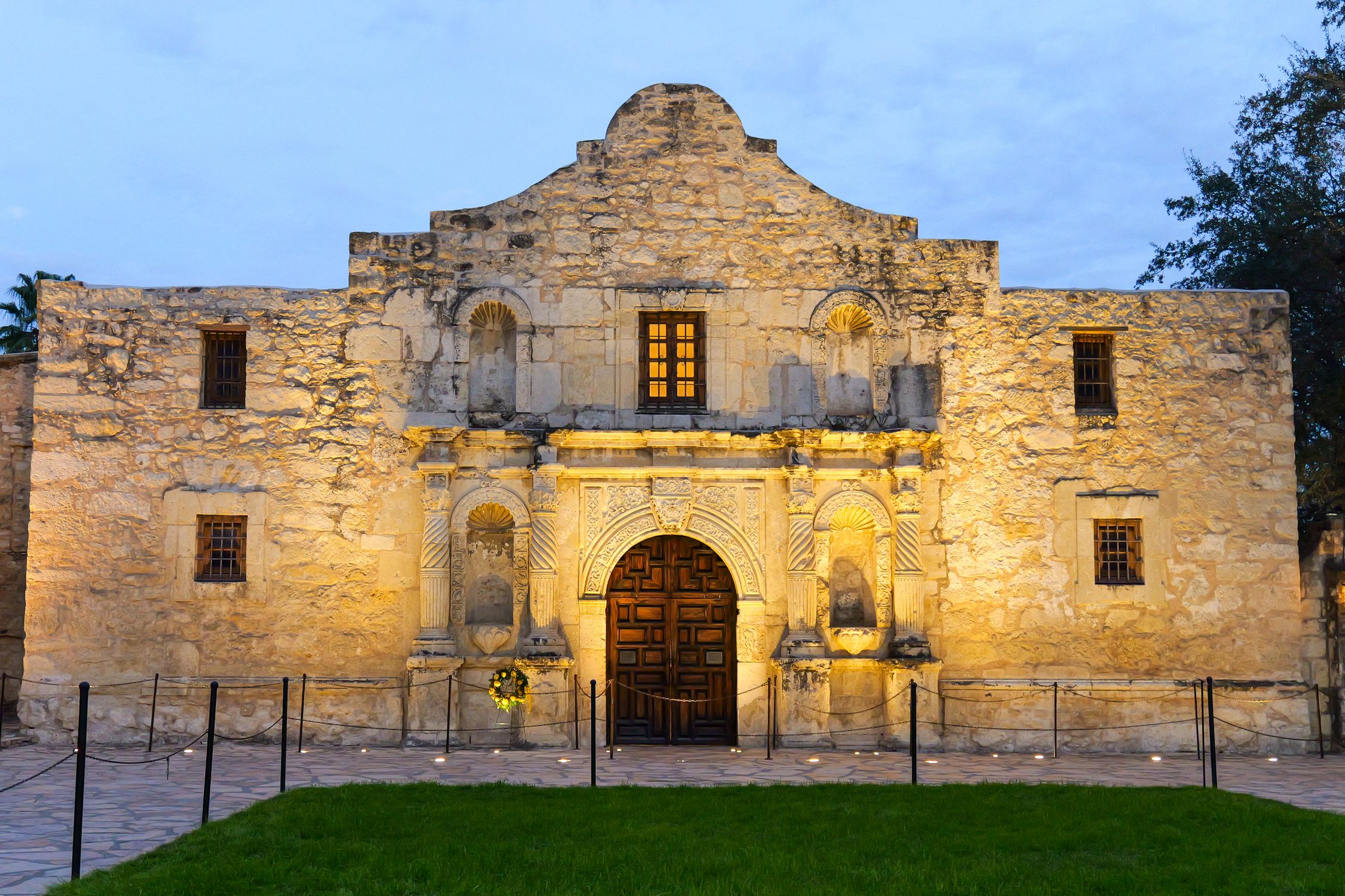 Discover the iconic Alamo Mission's facade beautifully illuminated at dusk in San Antonio, Texas.