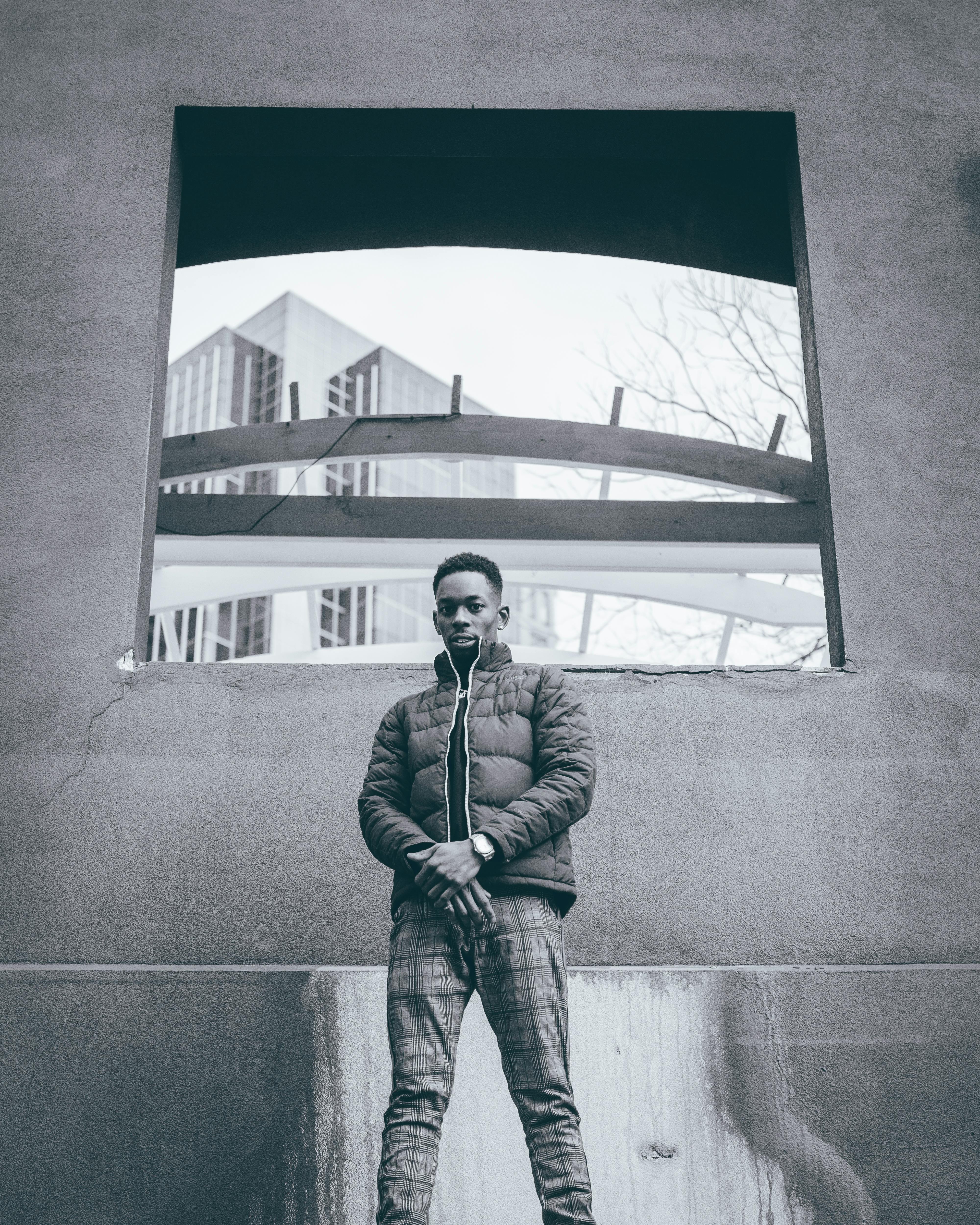 城市中的年轻人以现代建筑为背景，采用单色拍摄