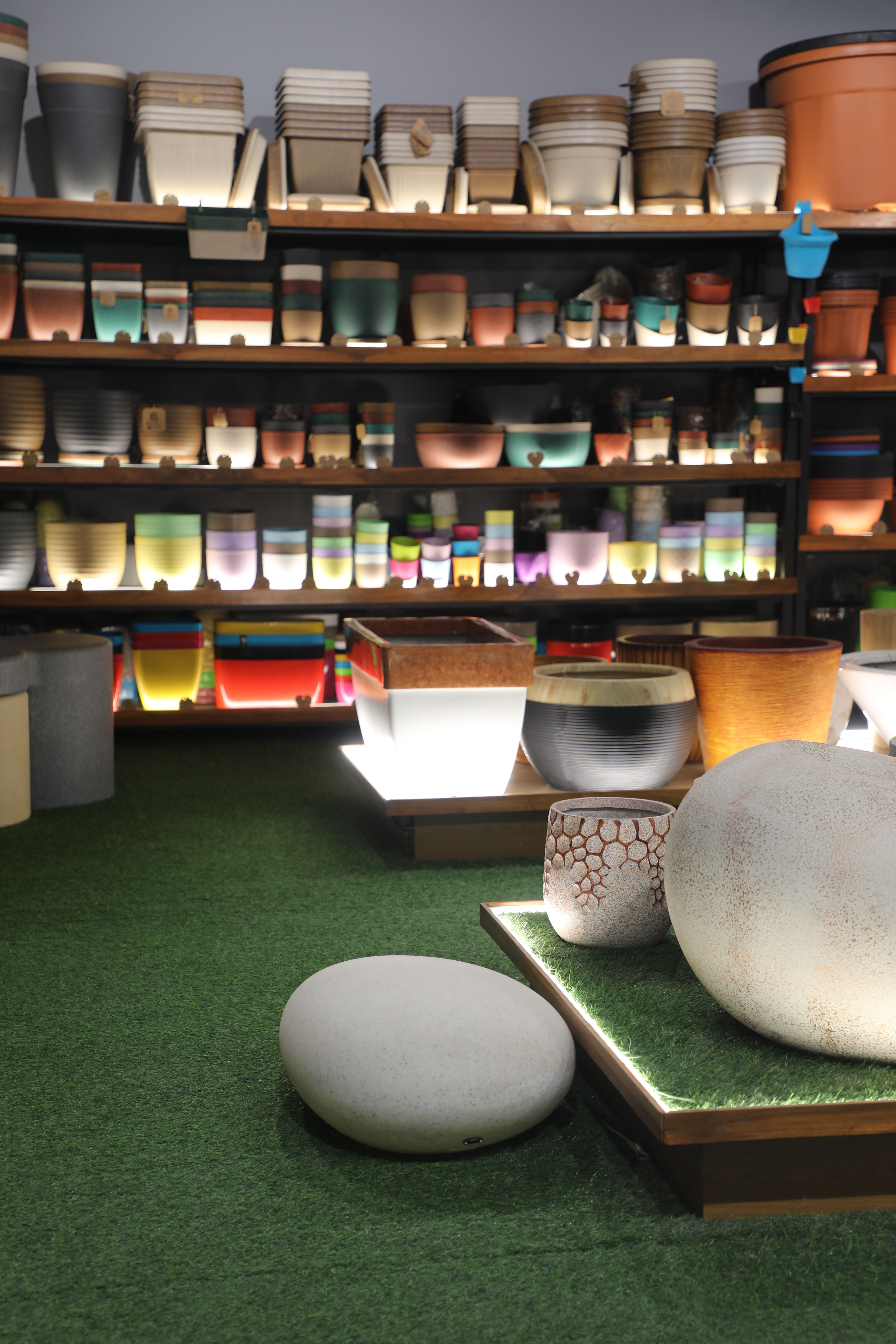 A vibrant indoor display of various colorful plant pots at a garden center, perfect for gardening enthusiasts.
