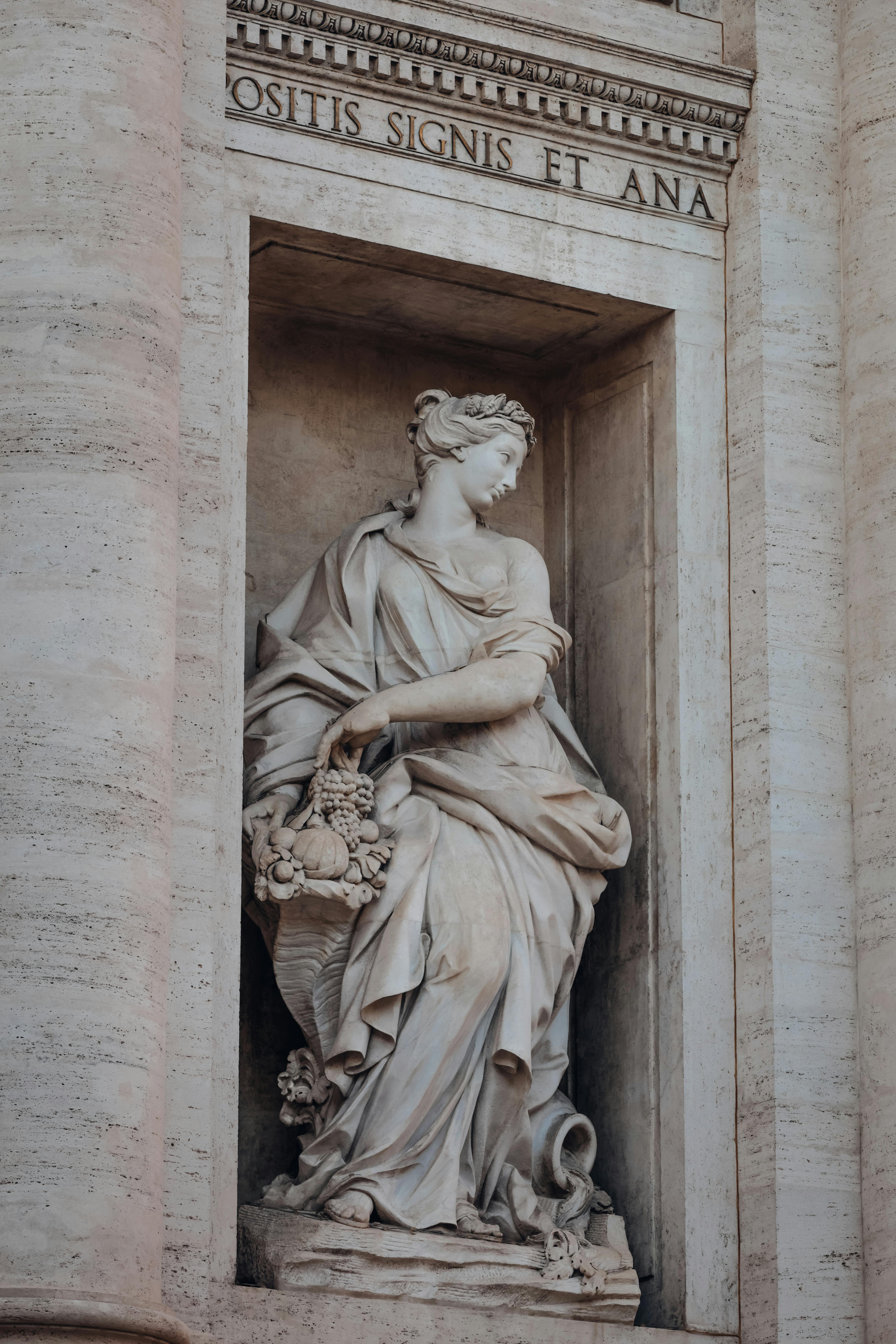 Classical marble statue on an architectural facade captured in natural light.