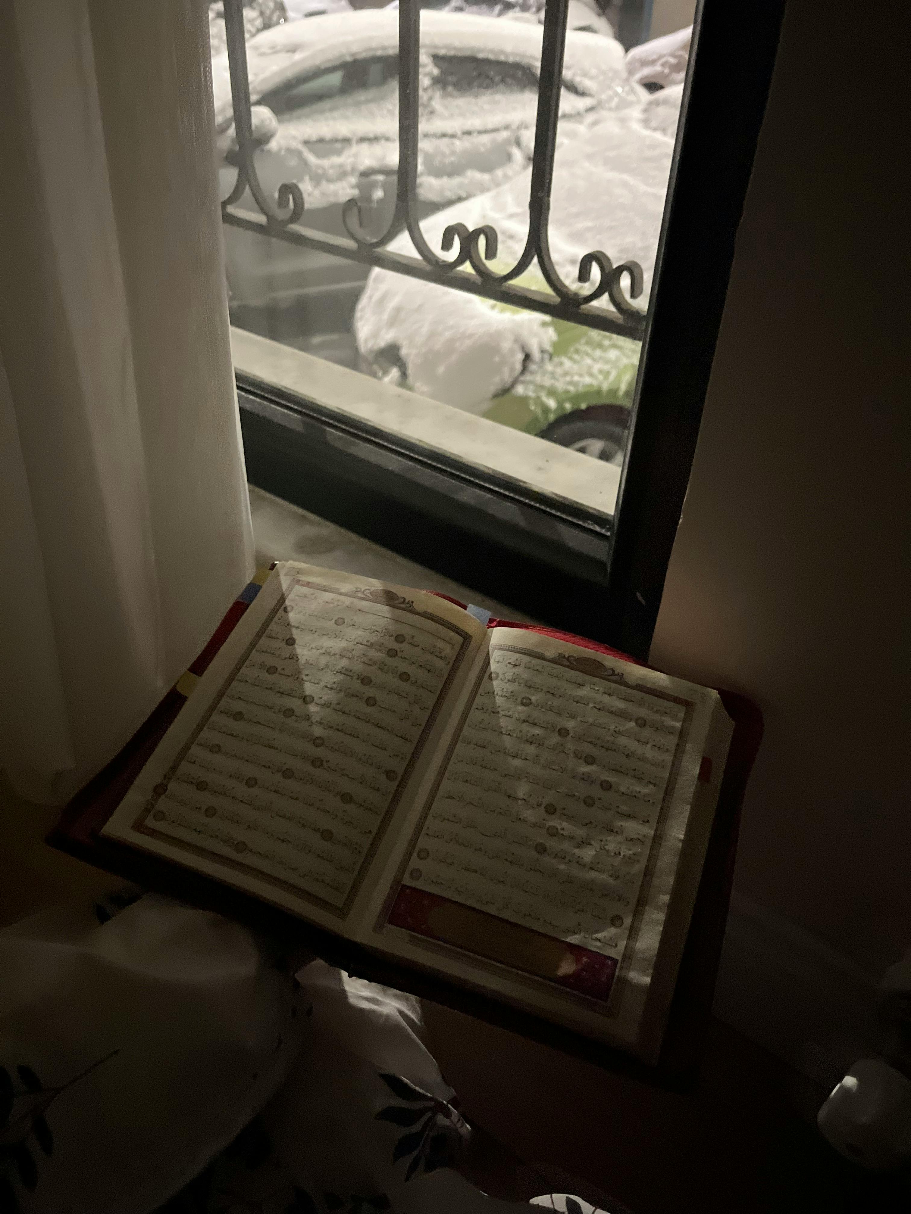 Ücretsiz İstanbul'da karlı bir manzaraya bakan bir pencerenin önünde açık bir kitap duruyor. Stok Fotoğraflar