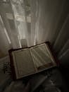 Holy Book by a Window with Sheer Curtains