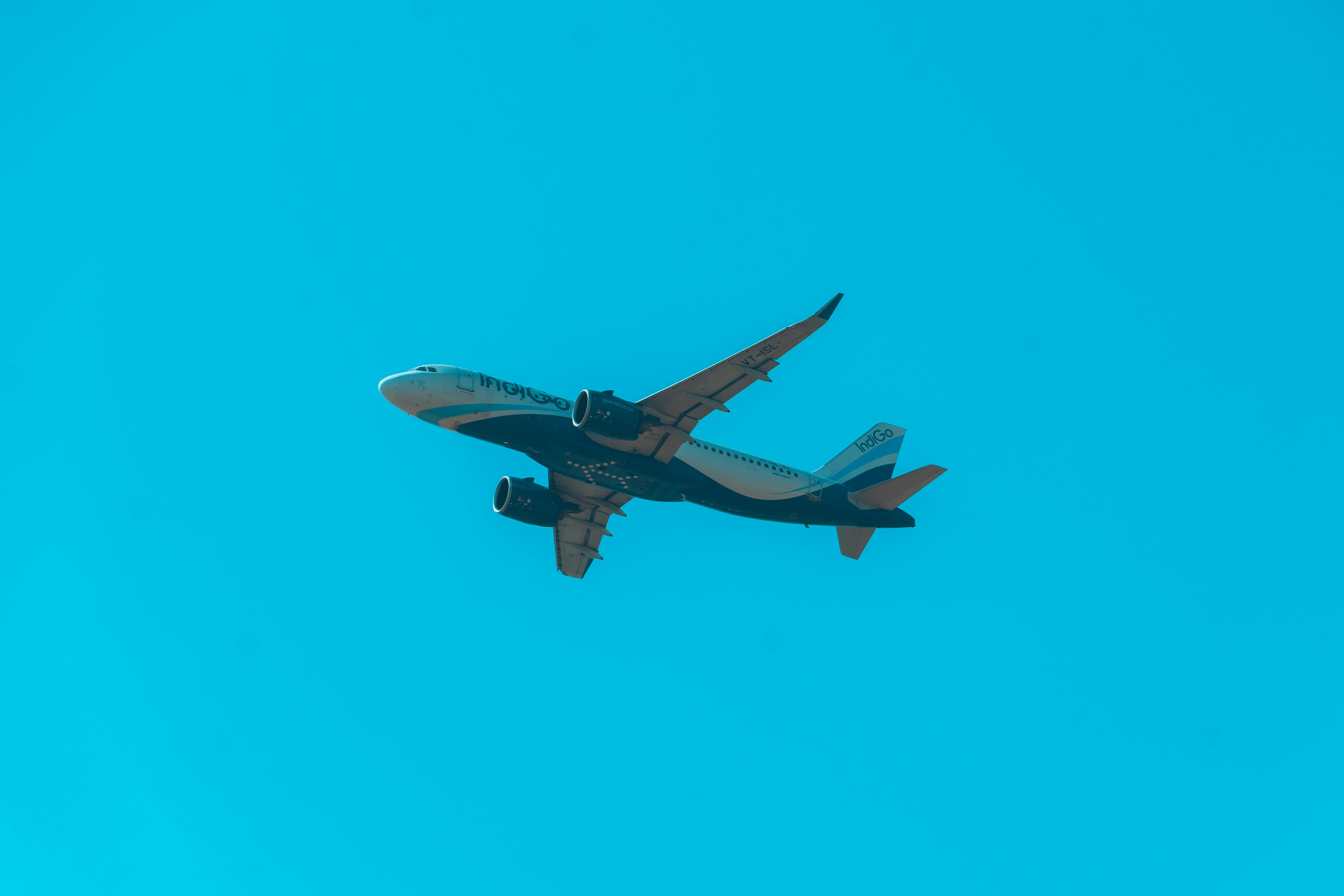 Free A commercial airplane soaring through a clear blue sky, highlighting aviation travel. Stock Photo