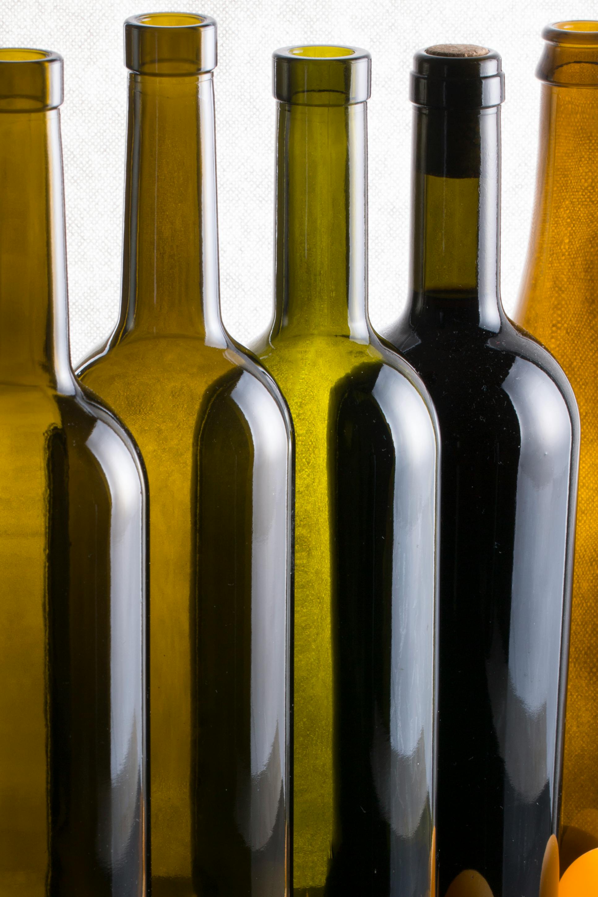A stylish array of wine bottles with varying shades and reflections, perfect for refined decor themes.