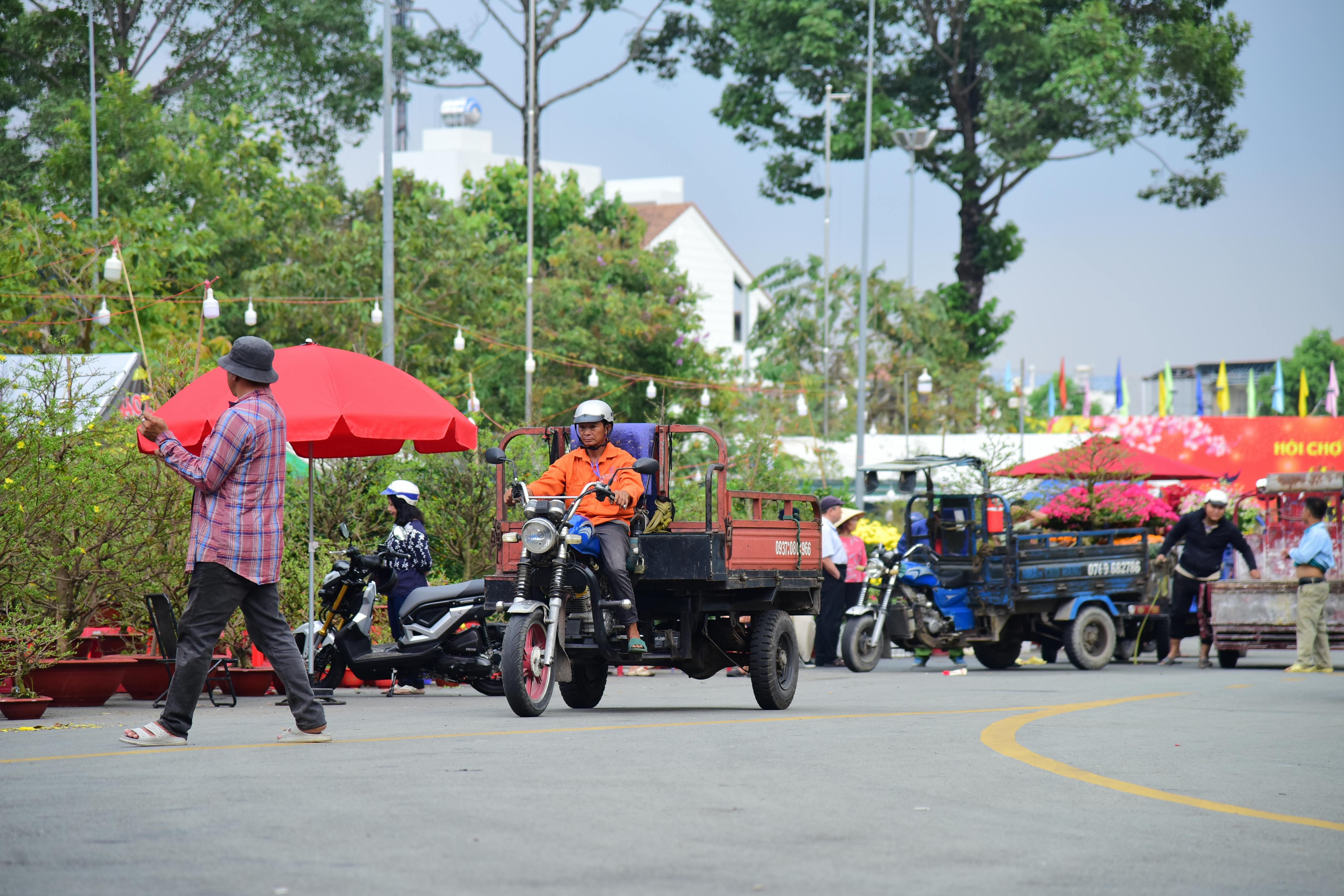 Vibrant street market scene featuring motorbikes and vendors on a sunny day.