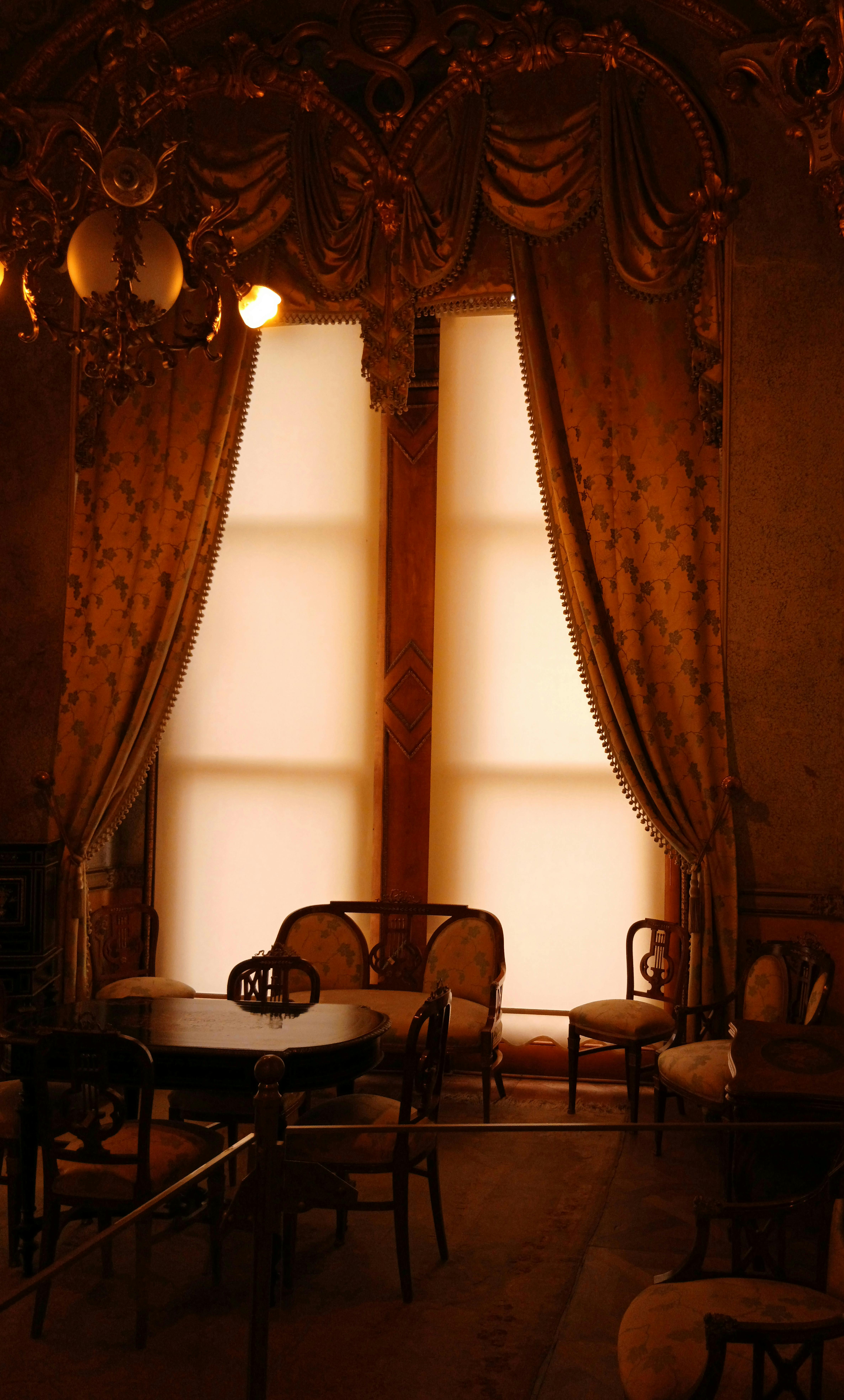 Gratis Ruangan yang hangat dan bergaya vintage dengan tirai berornamen dan furnitur antik. Sangat cocok untuk tema sejarah. Foto Stok