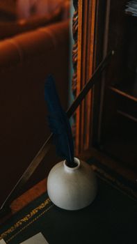 Elegant vintage setting with a quill pen in an inkwell on a classic wooden desk.