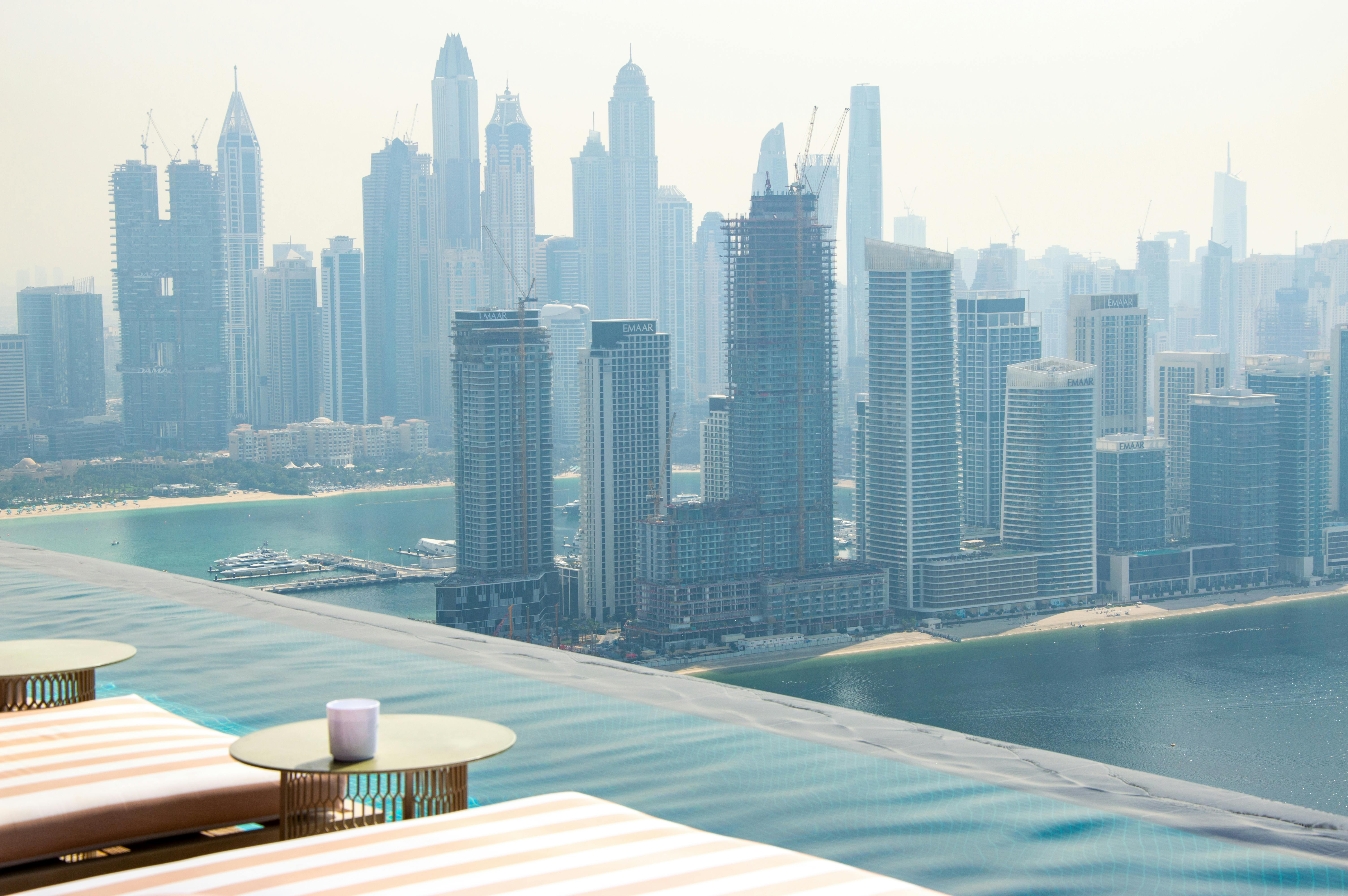 Stunning view of Dubai's skyline from an infinity pool, showcasing modern architecture and luxury li
