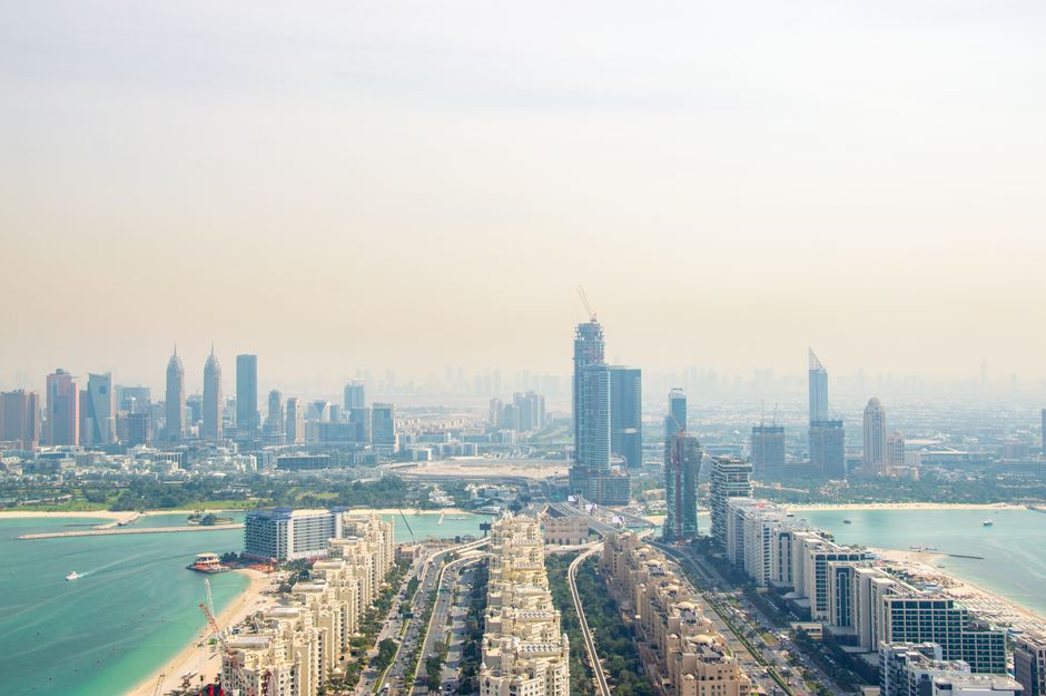 Unbeatable Helicopter Ride Over Dubai Burj Khalifa & Palm – Optional Pickup Review Review 2026 - A scenic aerial view showcasing Dubai's impressive skyline and coastline with modern skyscrapers under hazy skies.