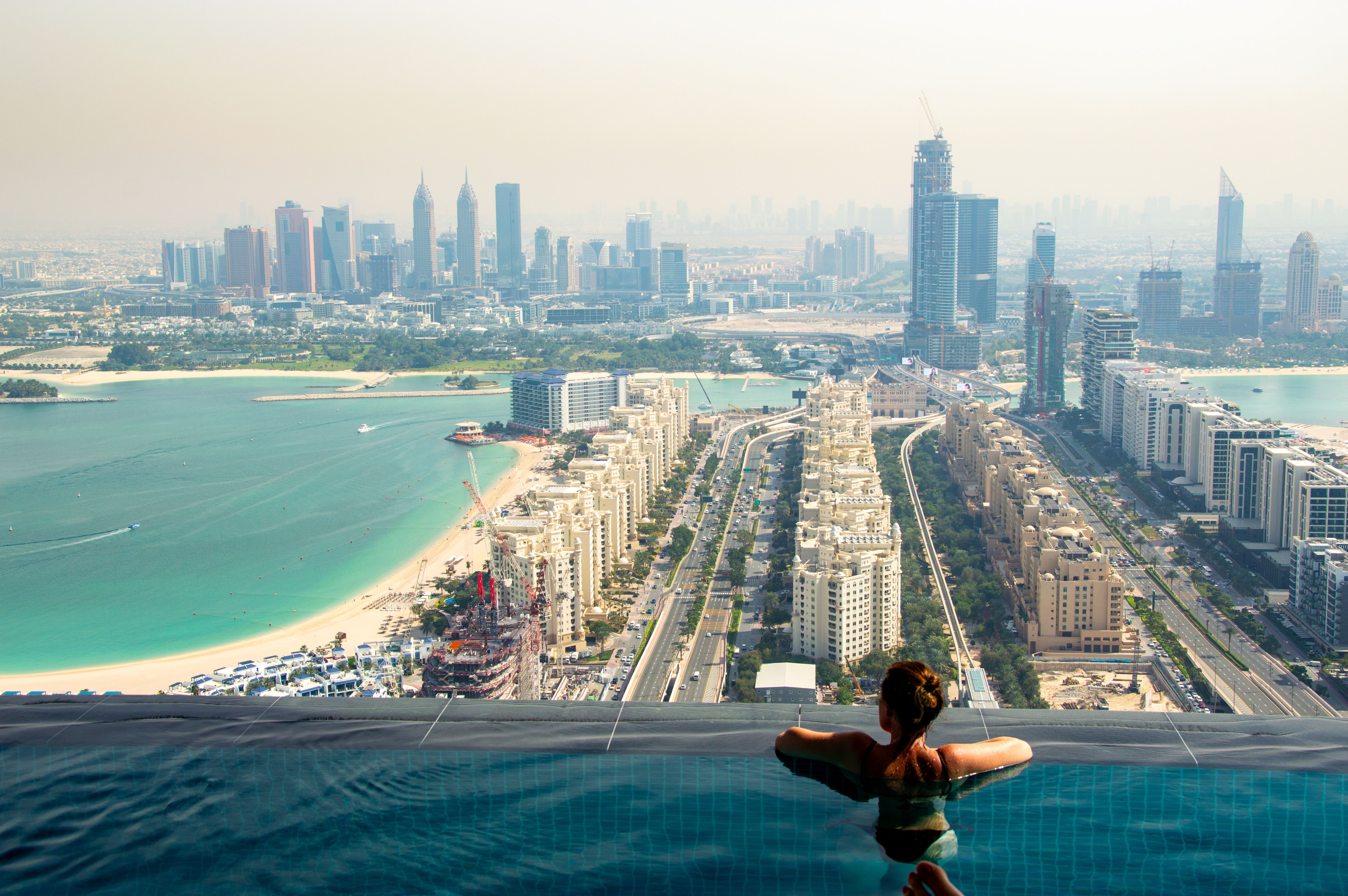 Relaxing in an infinity pool with a breathtaking view of the Dubai skyline and coast.