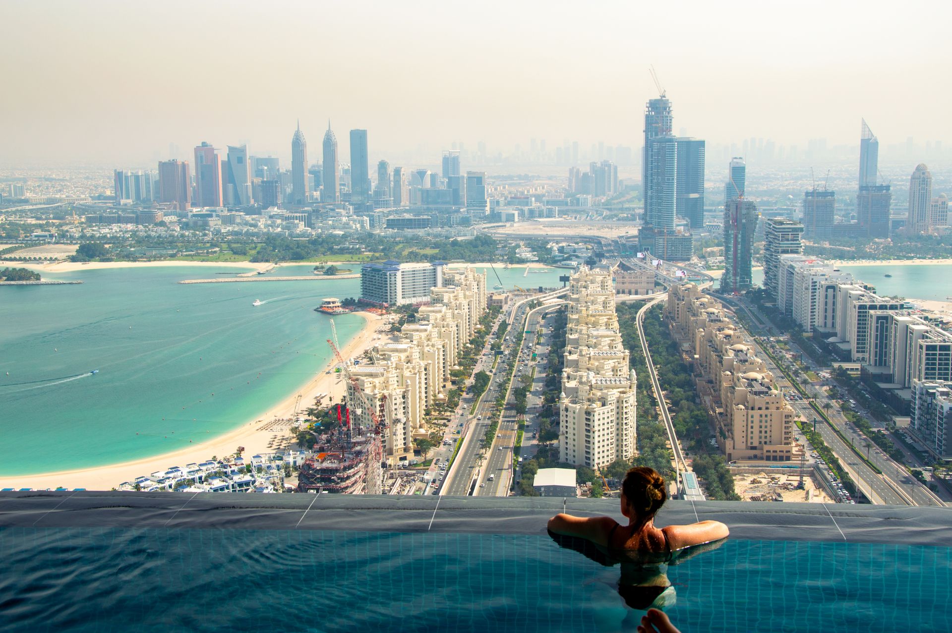 Relaxing in an infinity pool with a breathtaking view of the Dubai skyline and coast.