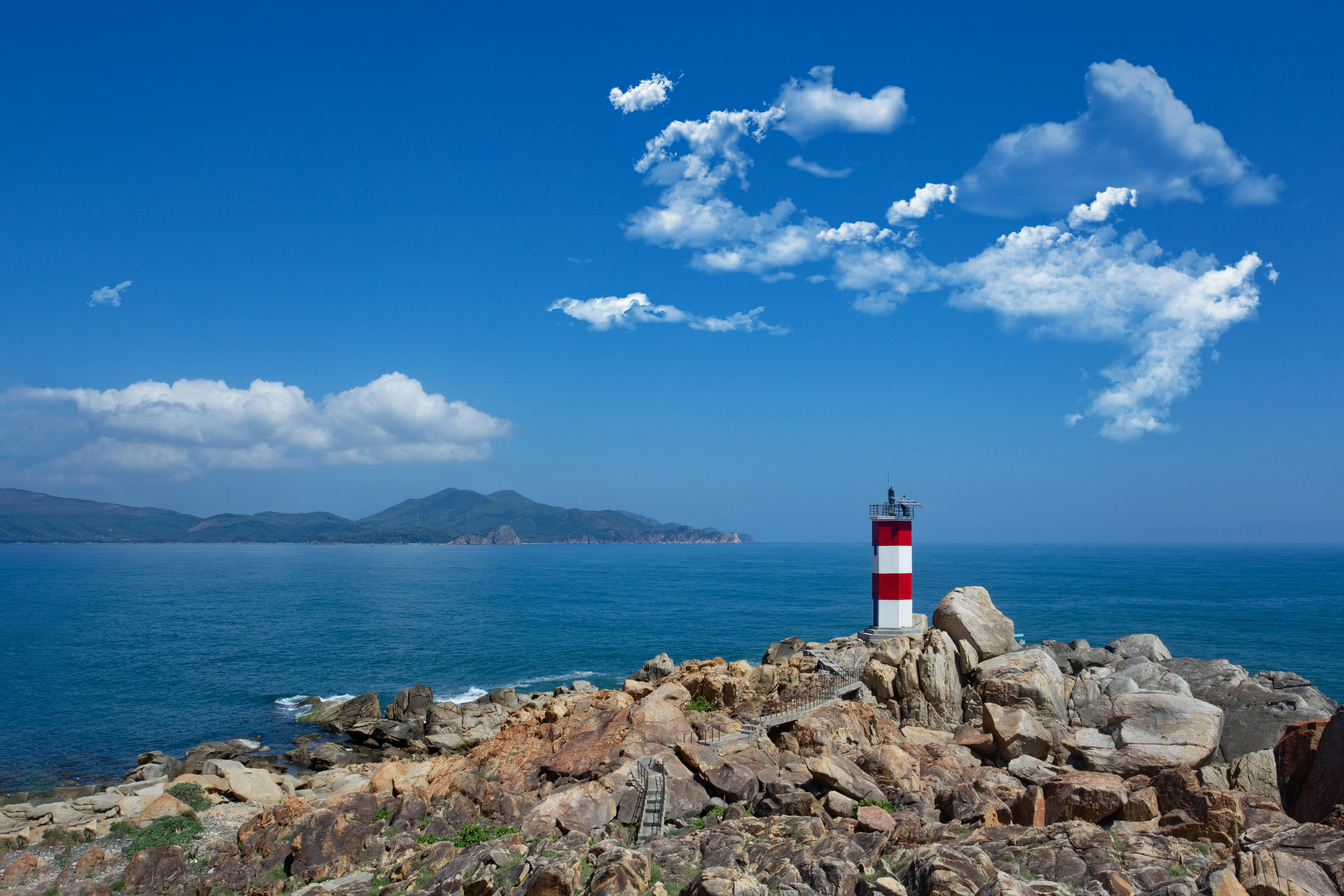 A stunning lighthouse scene on Vietnam's coast with vibrant sky and ocean.