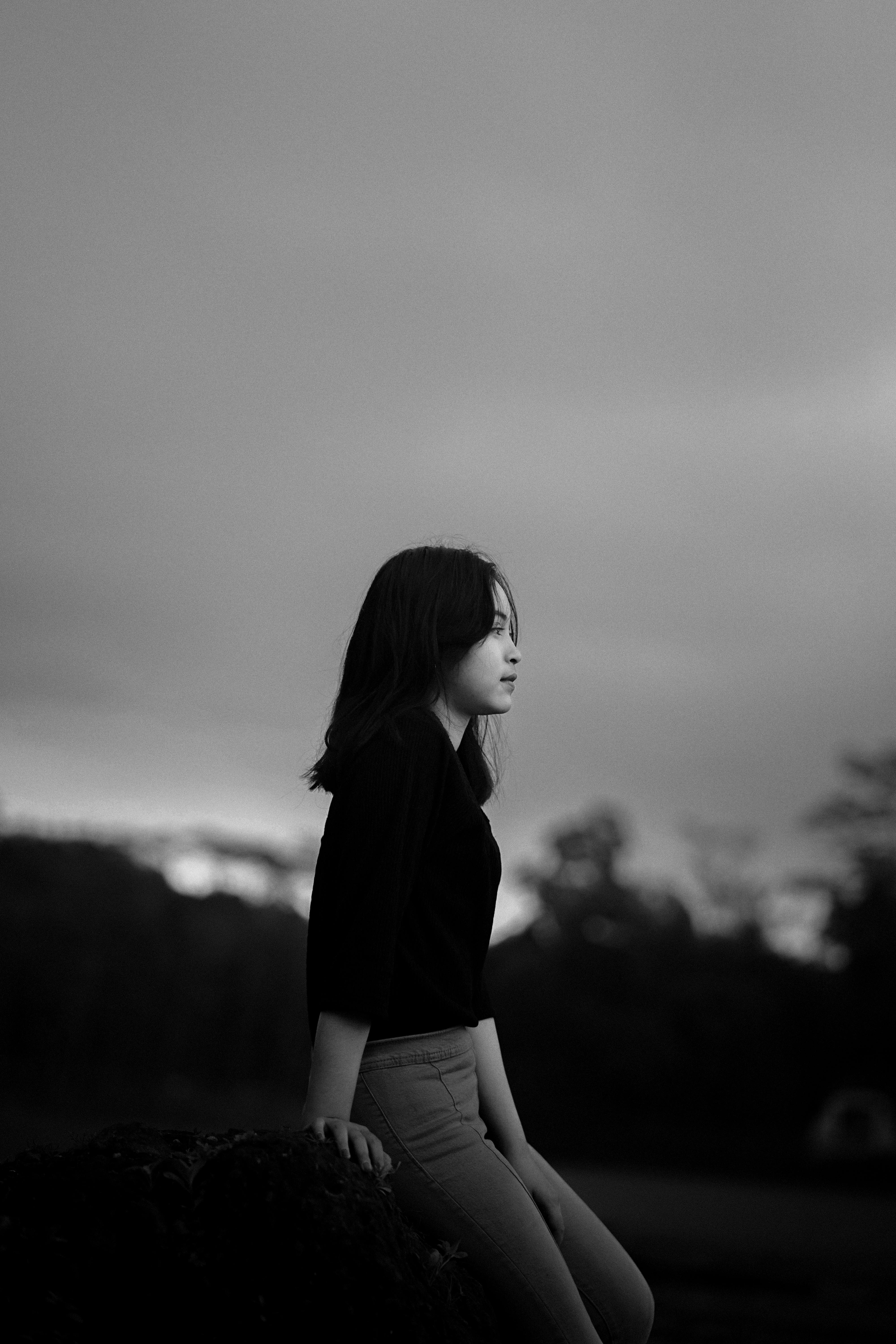 Gratis Ritratto in bianco e nero di una donna adulta seduta all'aperto, con sguardo contemplativo. Foto a disposizione