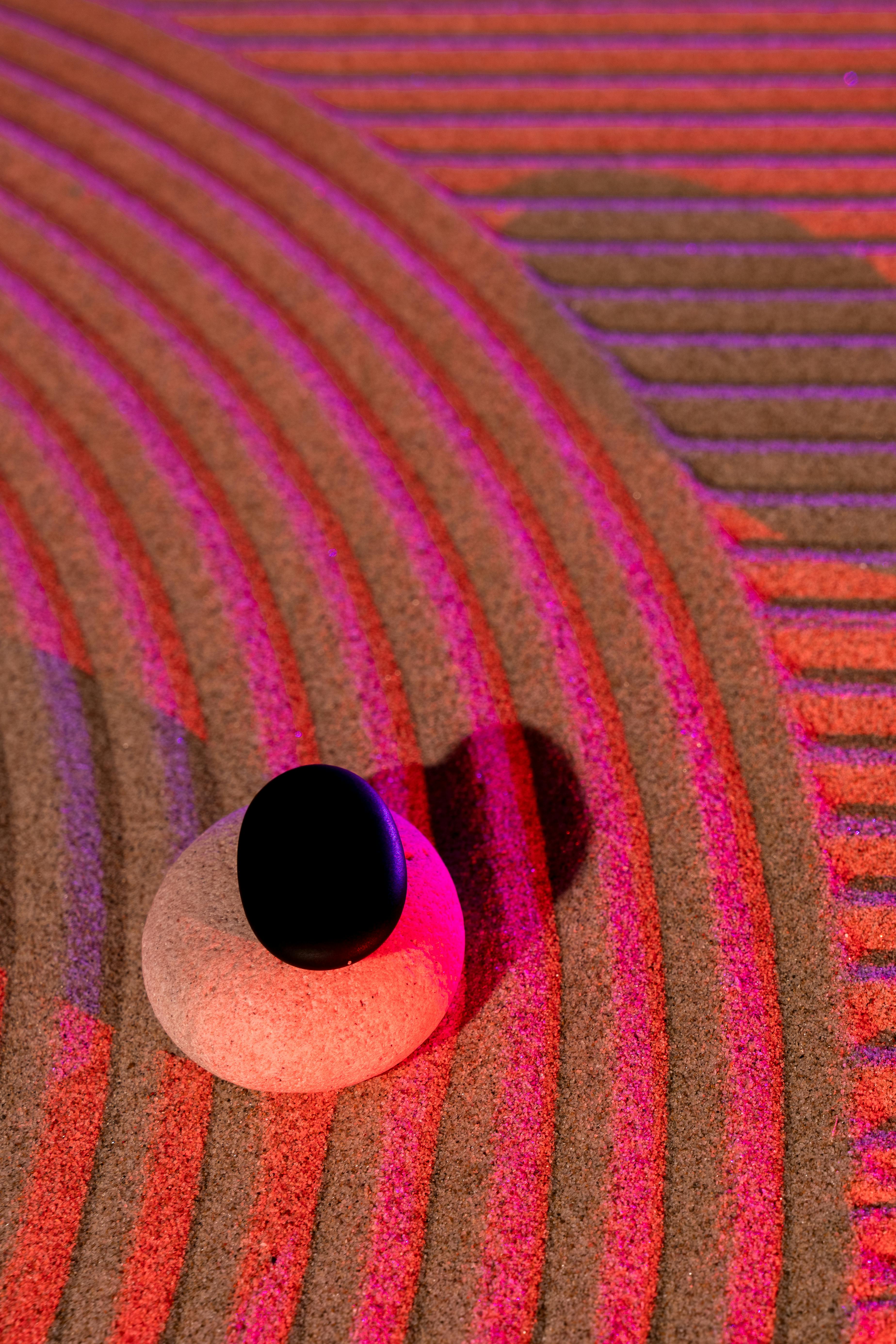 bezplatná Klidná zenová zahrada s kameny a barevným osvětlením vytvářející uklidňující atmosféru. Základová fotografie