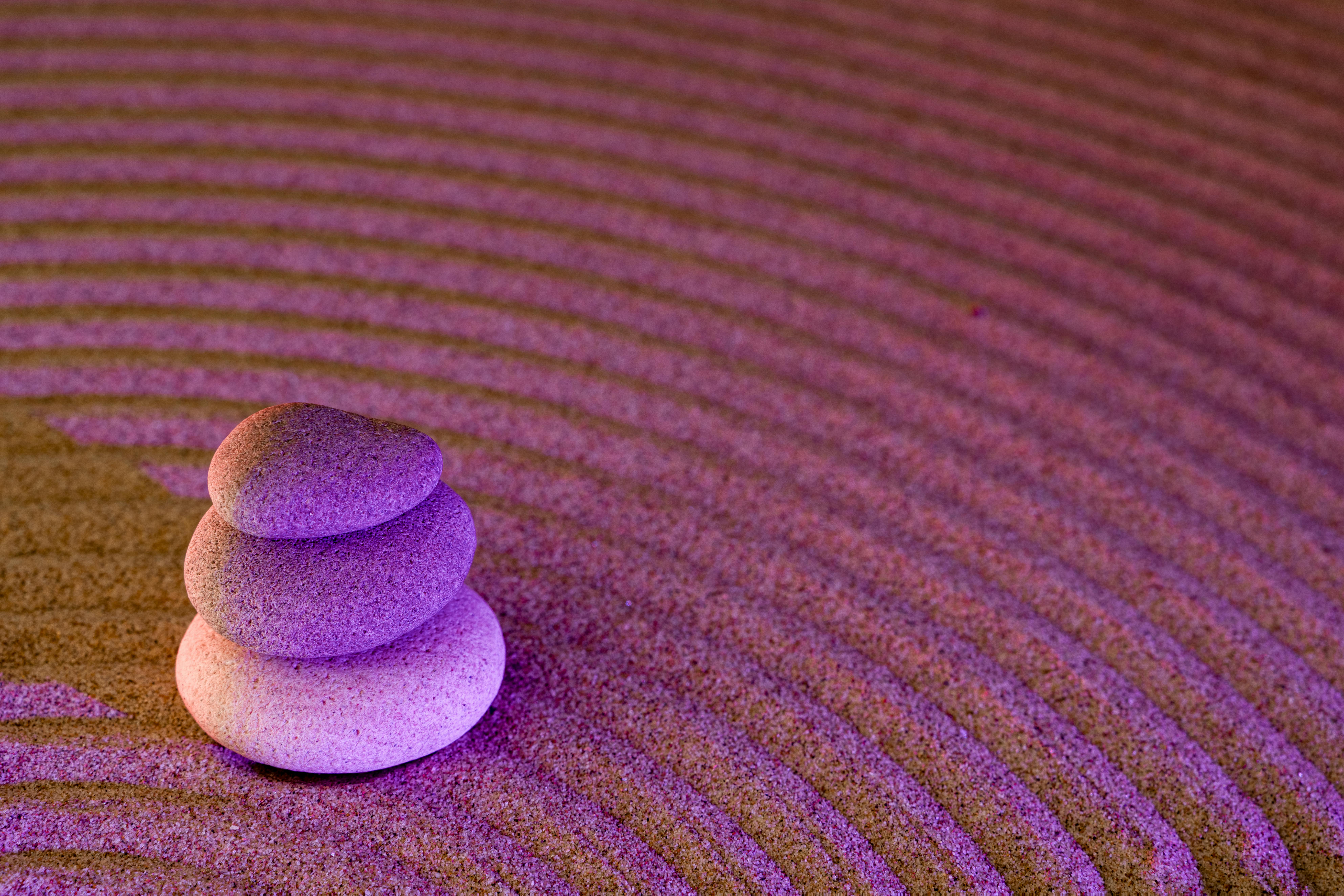Gratuit Grădină Zen senină cu pietre stivuite pe nisip greblat sub lumină violetă. Fotografie de stoc