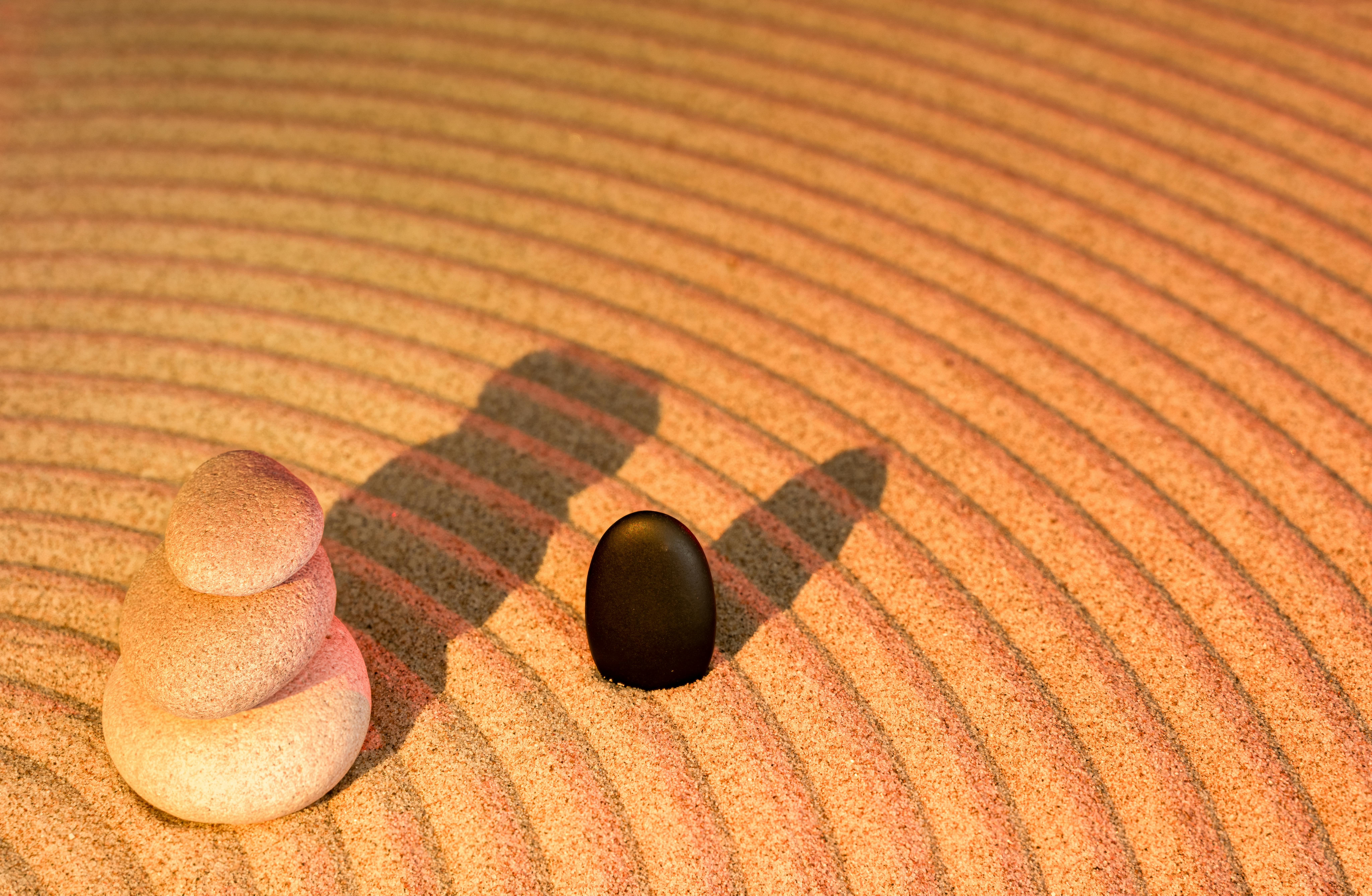 Free Tranquil Zen garden scene featuring stacked stones and sand patterns for meditation and relaxation. Stock Photo