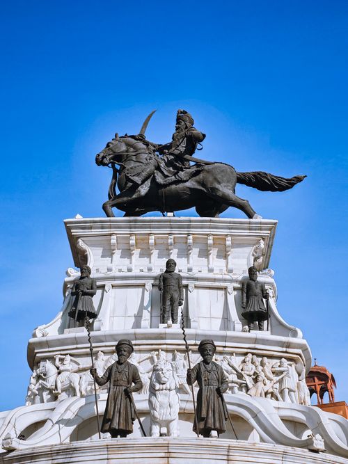 Free Dramatic monument featuring historical figures in Rupnagar, Punjab, India under a vibrant blue sky. Stock Photo
