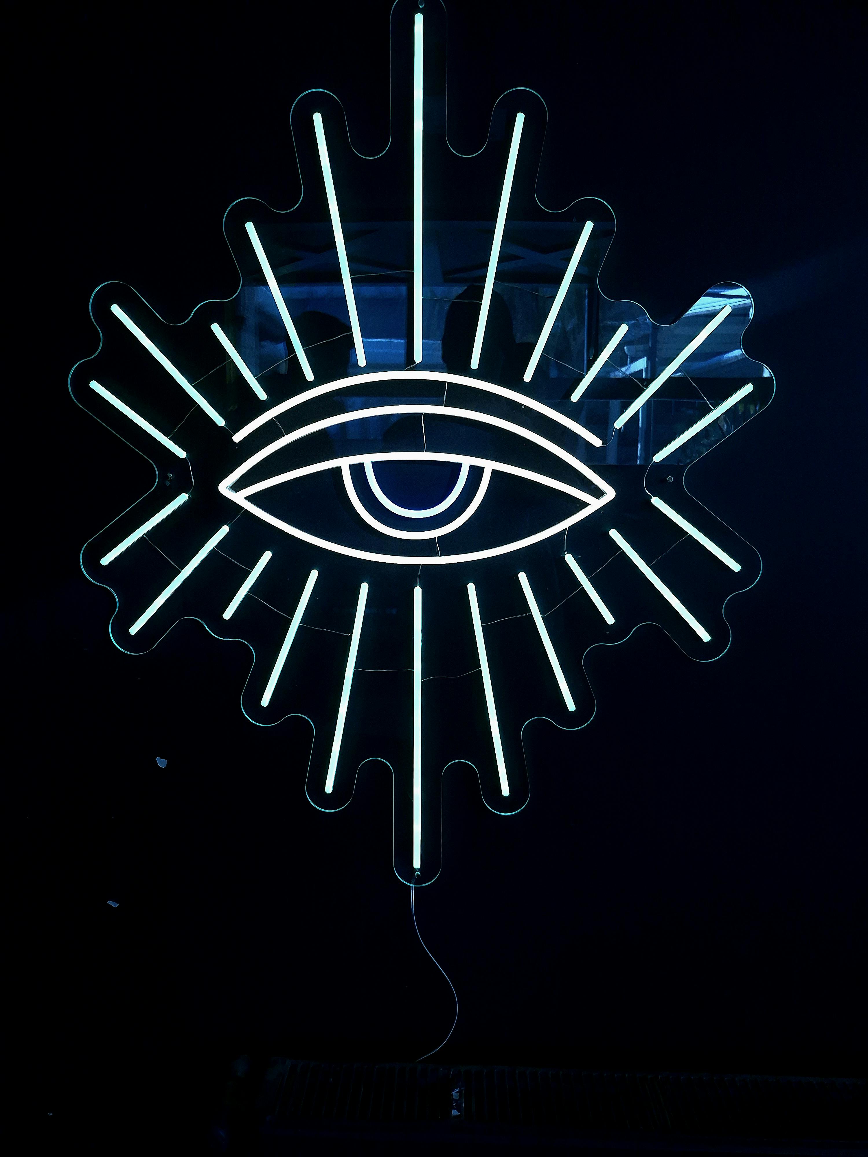 Free Striking neon eye with radiating lines on a dark backdrop, perfect for modern design projects. Stock Photo