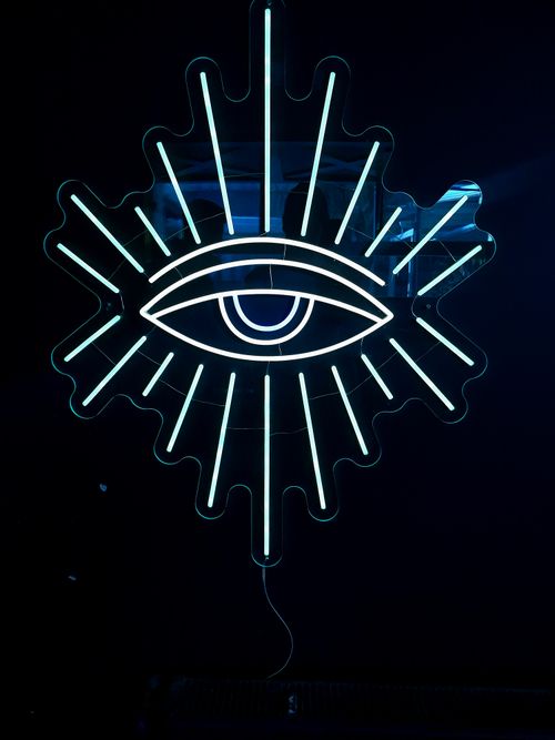 Free Striking neon eye with radiating lines on a dark backdrop, perfect for modern design projects. Stock Photo