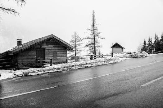 A black and white image of a snowy mountain chalet with a serene winter atmosphere.