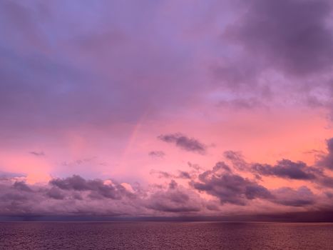 Stunning sunset over the ocean with pink and purple hues in the sky creating a serene atmosphere.