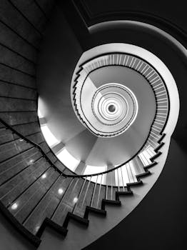 Black and white photo of a spiral staircase in Hamburg showcasing elegant architectural design.