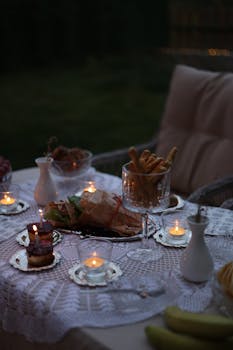 A beautifully arranged evening dinner table with candlelight outdoors, perfect for intimate gatherings.
