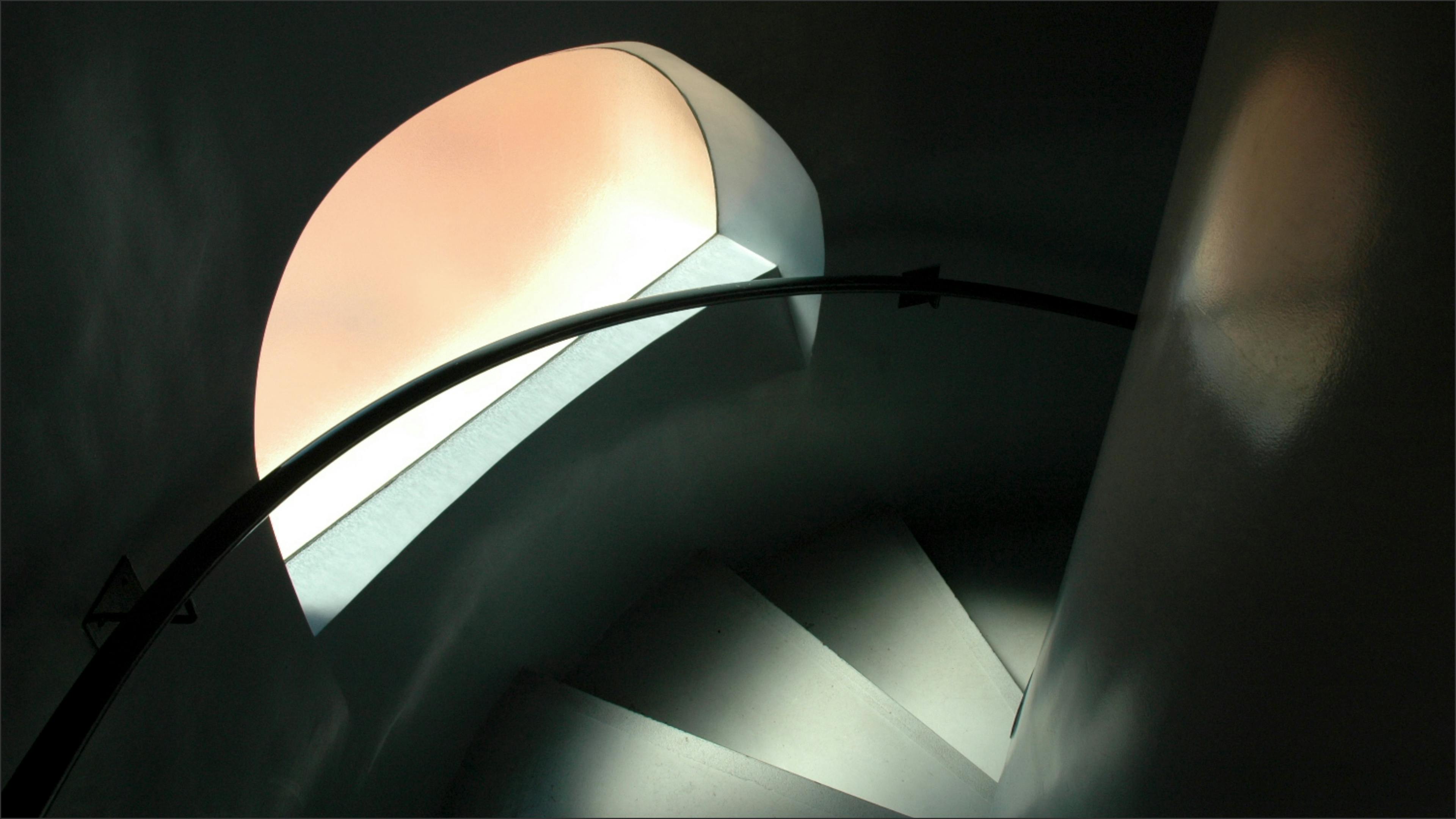 Kostenlos Eine Wendeltreppe, durch deren Bogenfenster sanftes Licht fällt. Stock-Foto