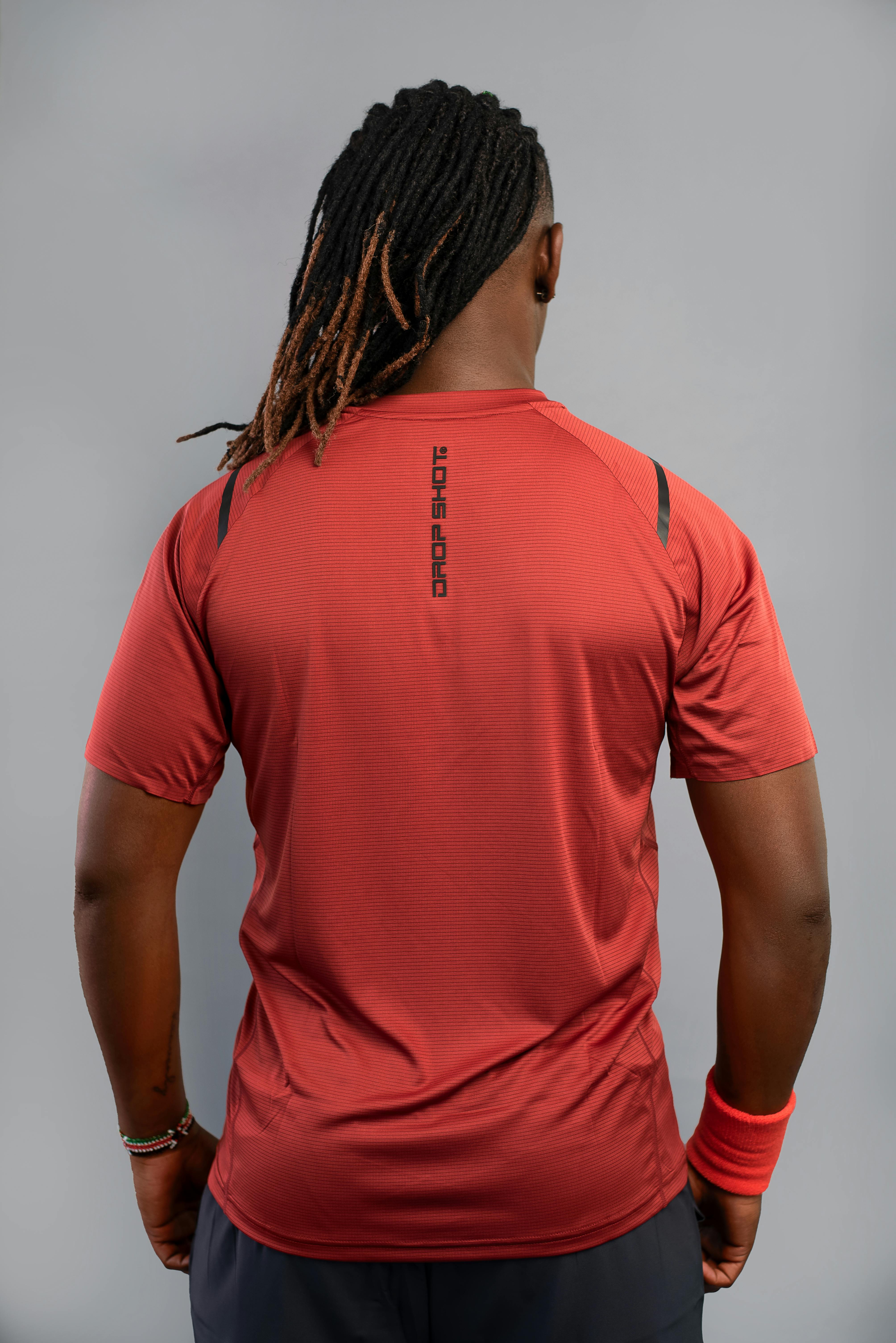 Δωρεάν Πίσω όψη ενός αθλητικού άνδρα με κόκκινα αθλητικά ρούχα σε ουδέτερο φόντο. Φωτογραφία από στοκ φωτογραφιών