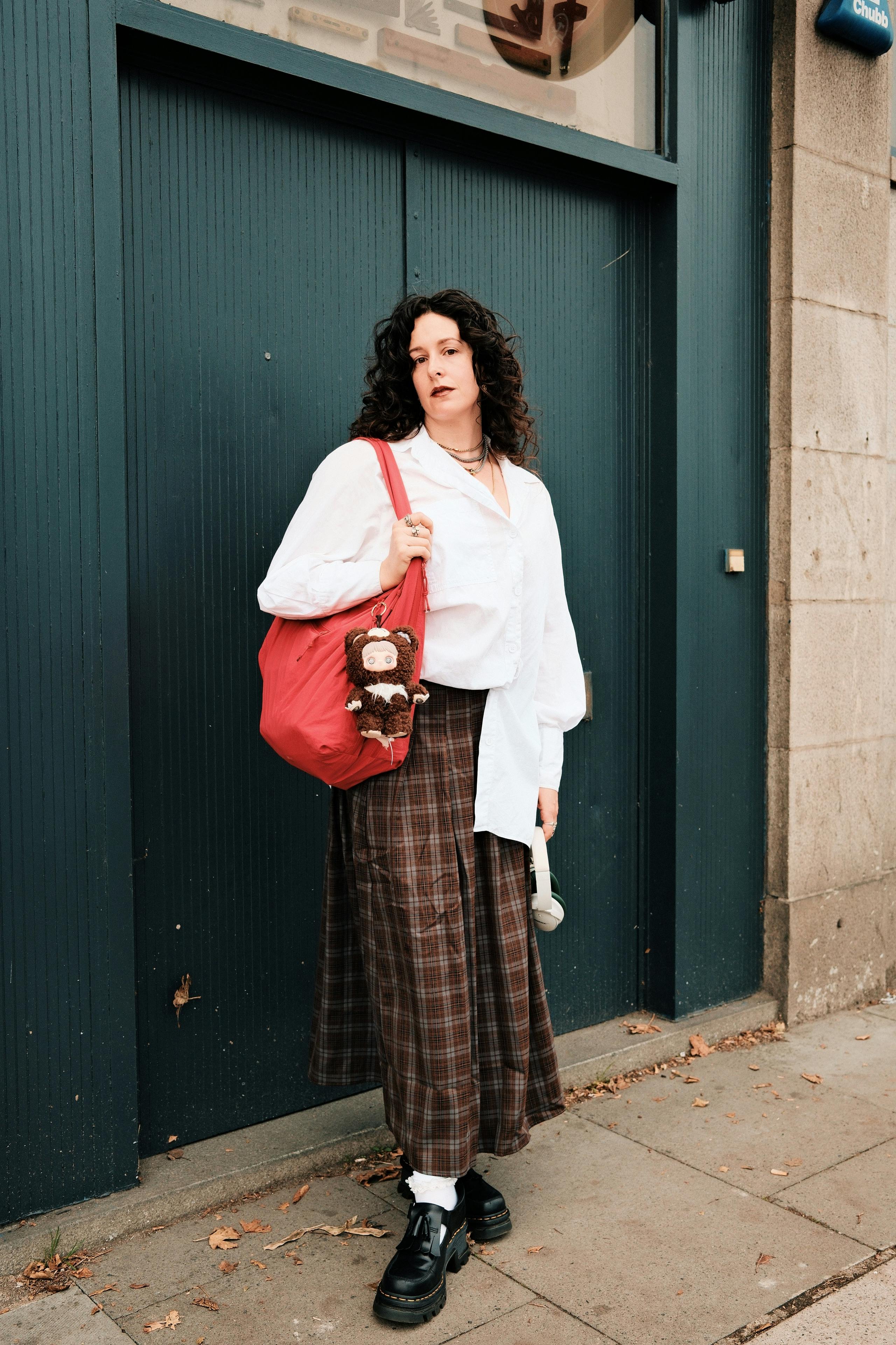 Stylish woman poses with a red bag in Aberdeen, Scotland. Urban fashion at its best.