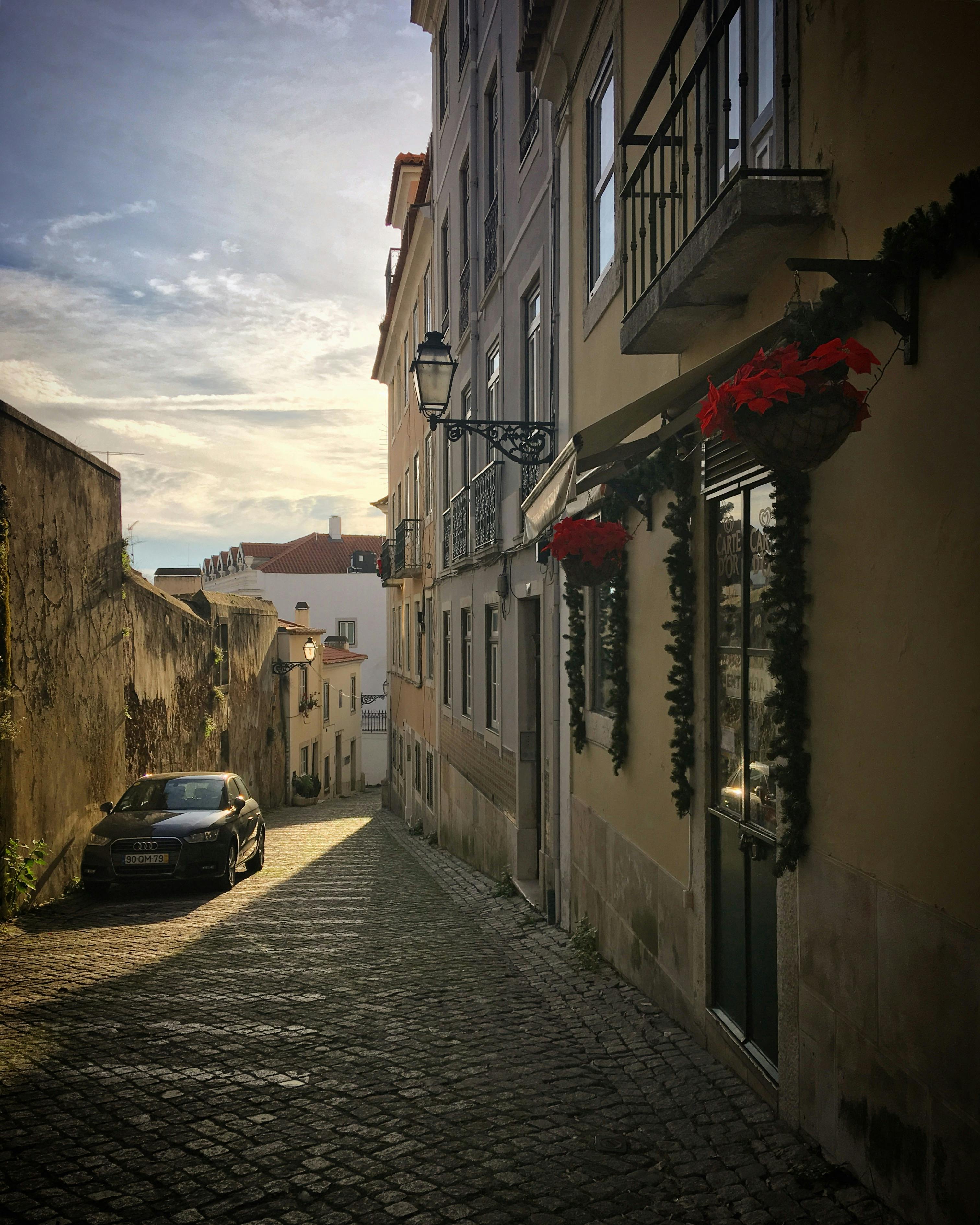 ingyenes Macskaköves utca Lisszabonban, Portugáliában, ünnepi dekorációval és csendes reggeli hangulattal. Stockfotó