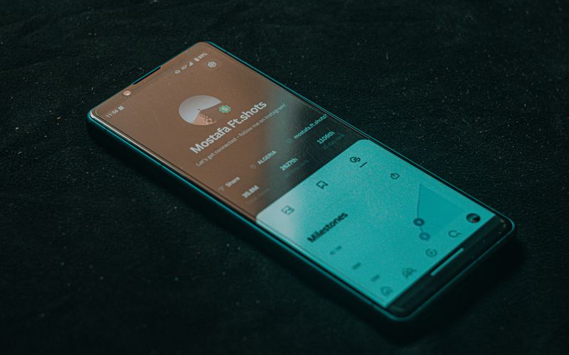 Smartphone displaying app screen on dark surface