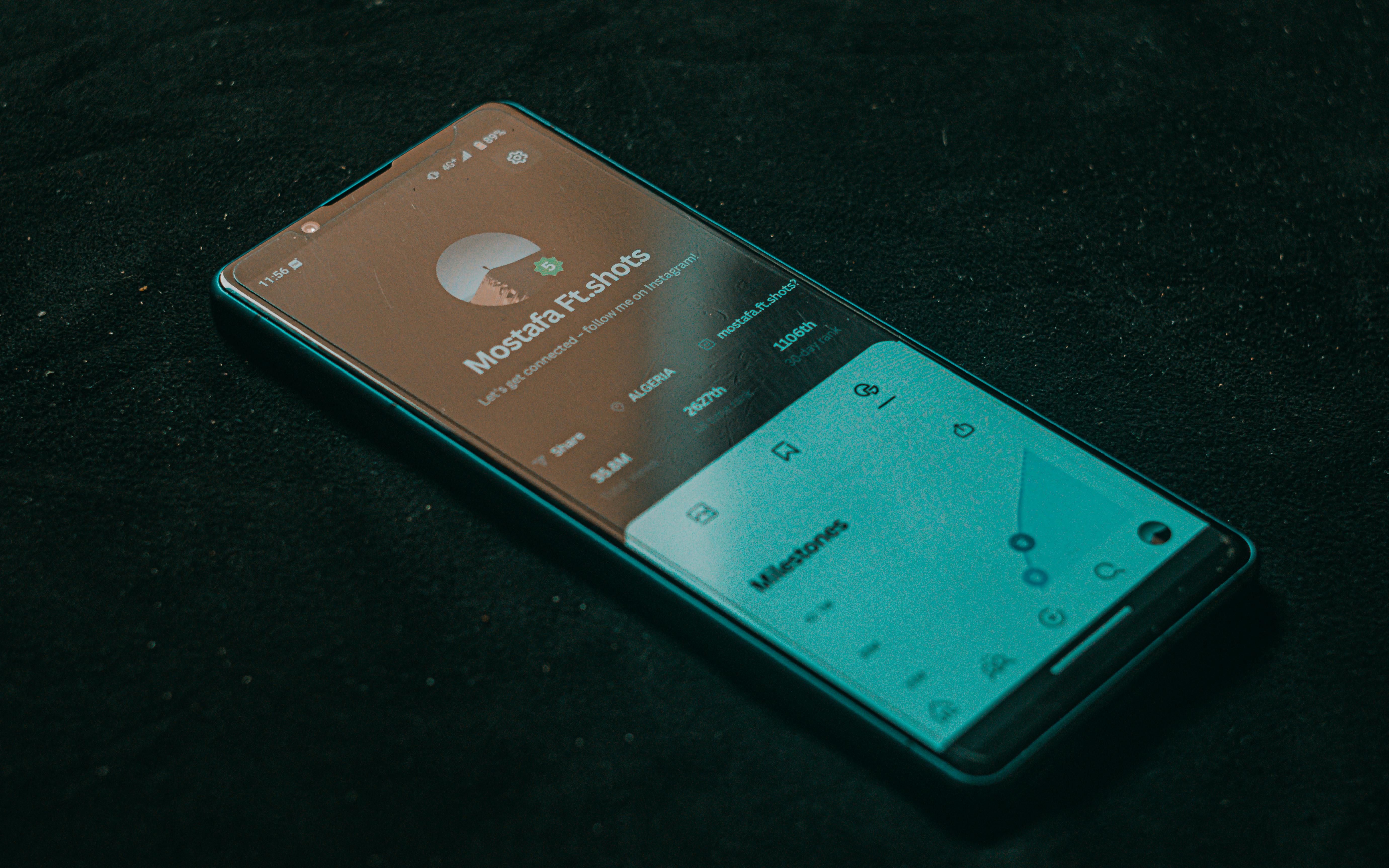 Gratis Un teléfono inteligente que muestra la pantalla de una aplicación se encuentra sobre una superficie oscura, resaltando la tecnología. Foto de stock