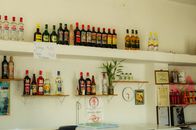 A lively bar interior with assorted liquor bottles on wall shelves and a decorative plant.