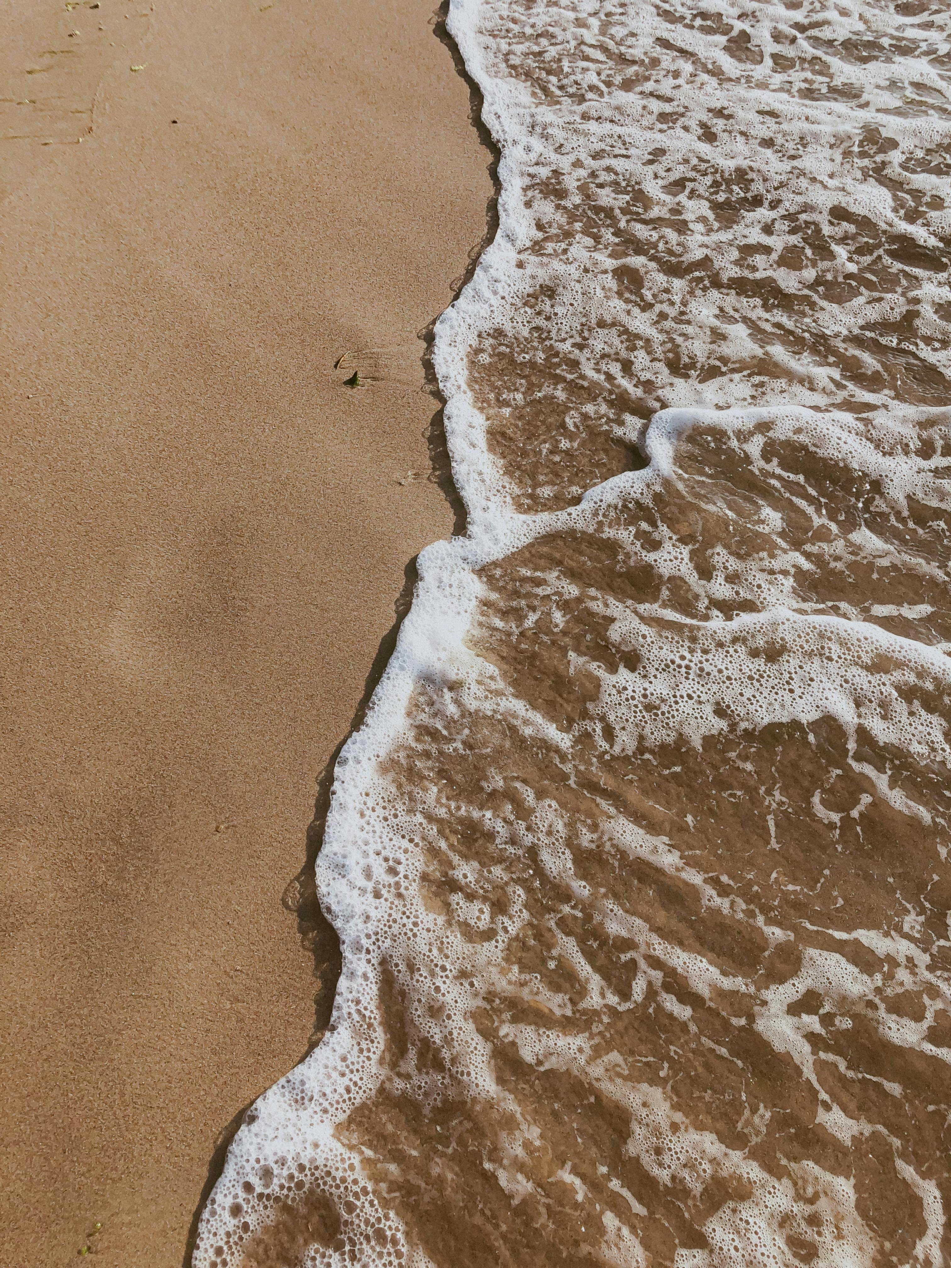 Δωρεάν Γαλήνια εικόνα με απαλά κύματα του ωκεανού που χαϊδεύουν μια αμμώδη παραλία, ιδανική για θέματα χαλάρωσης. Φωτογραφία από στοκ φωτογραφιών