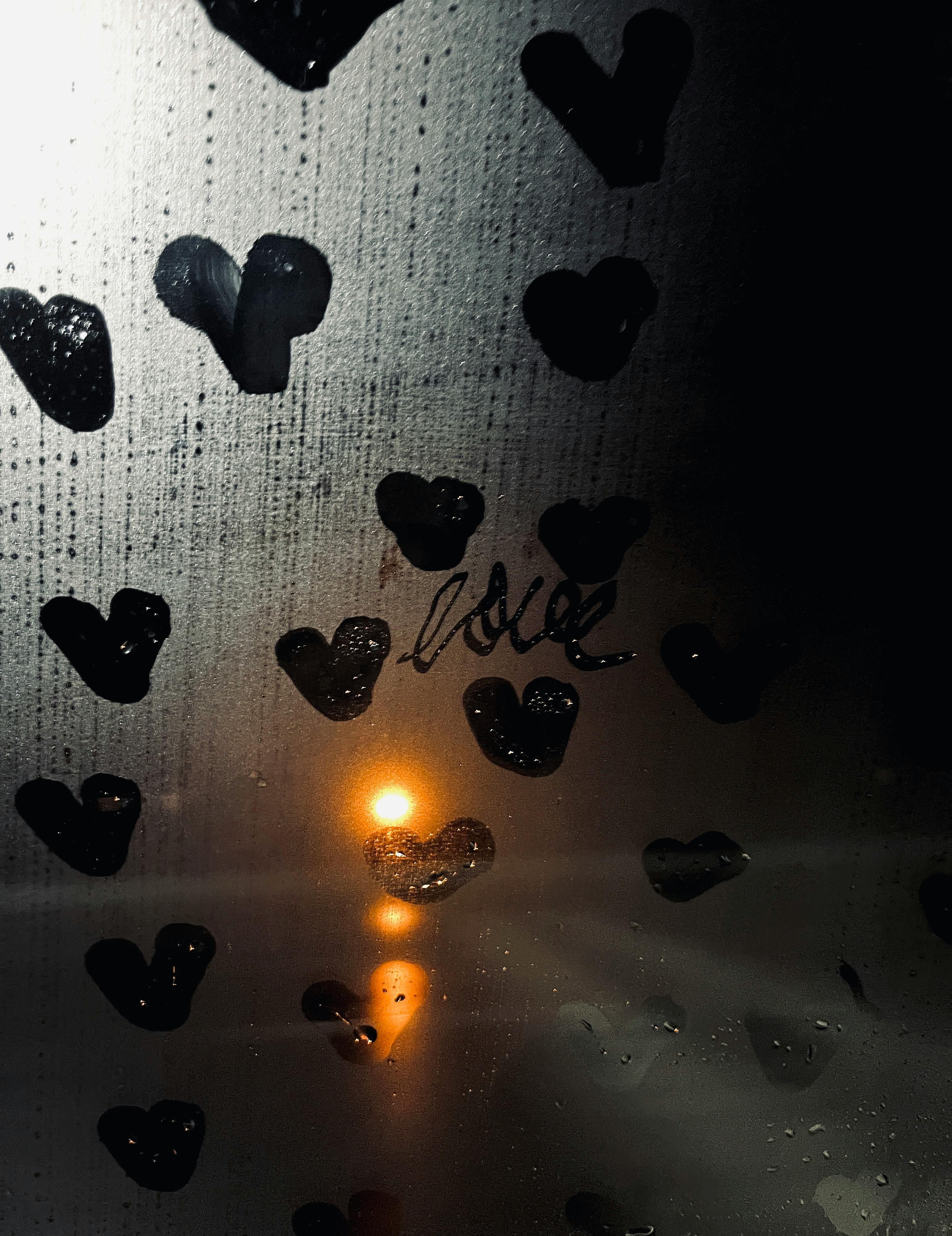 Ücretsiz Pencereden çekilmiş, üzerine kalp şekilleri çizilmiş ve 'aşk' kelimesi parıldayan ışıklarla vurgulanmış, buğulu bir görüntü. Stok Fotoğraflar