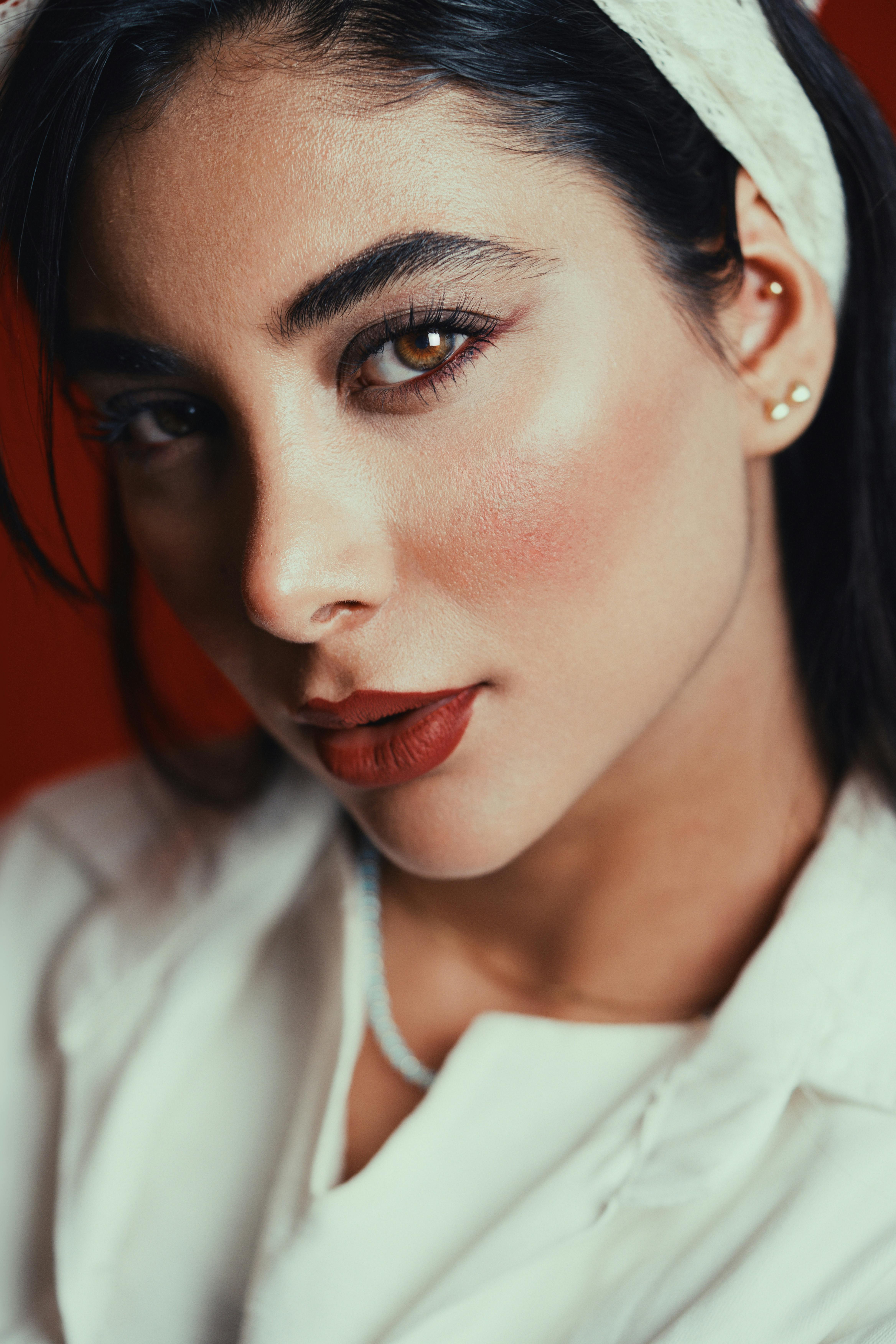 Gratis Ritratto ravvicinato di una donna con rossetto rosso e sguardo penetrante. Foto a disposizione