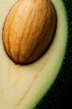 Detailed close-up of a ripe avocado showcasing the seed and texture of the flesh and skin.