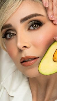 Elegant portrait emphasizing skincare and beauty with avocado detail.