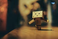 Toy Robot Figure on Wooden Surface with Lights